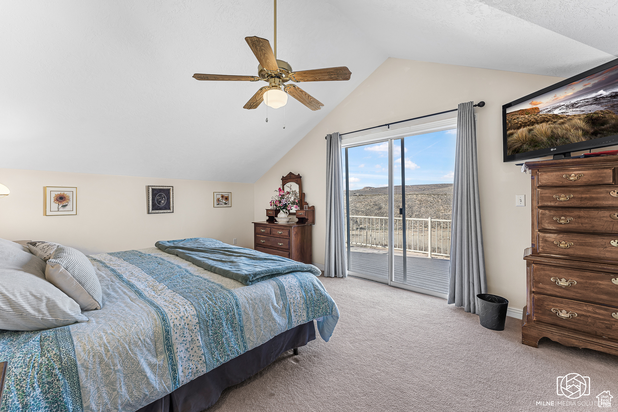 Bedroom with ceiling fan, access to exterior, lofted ceiling, and light carpet