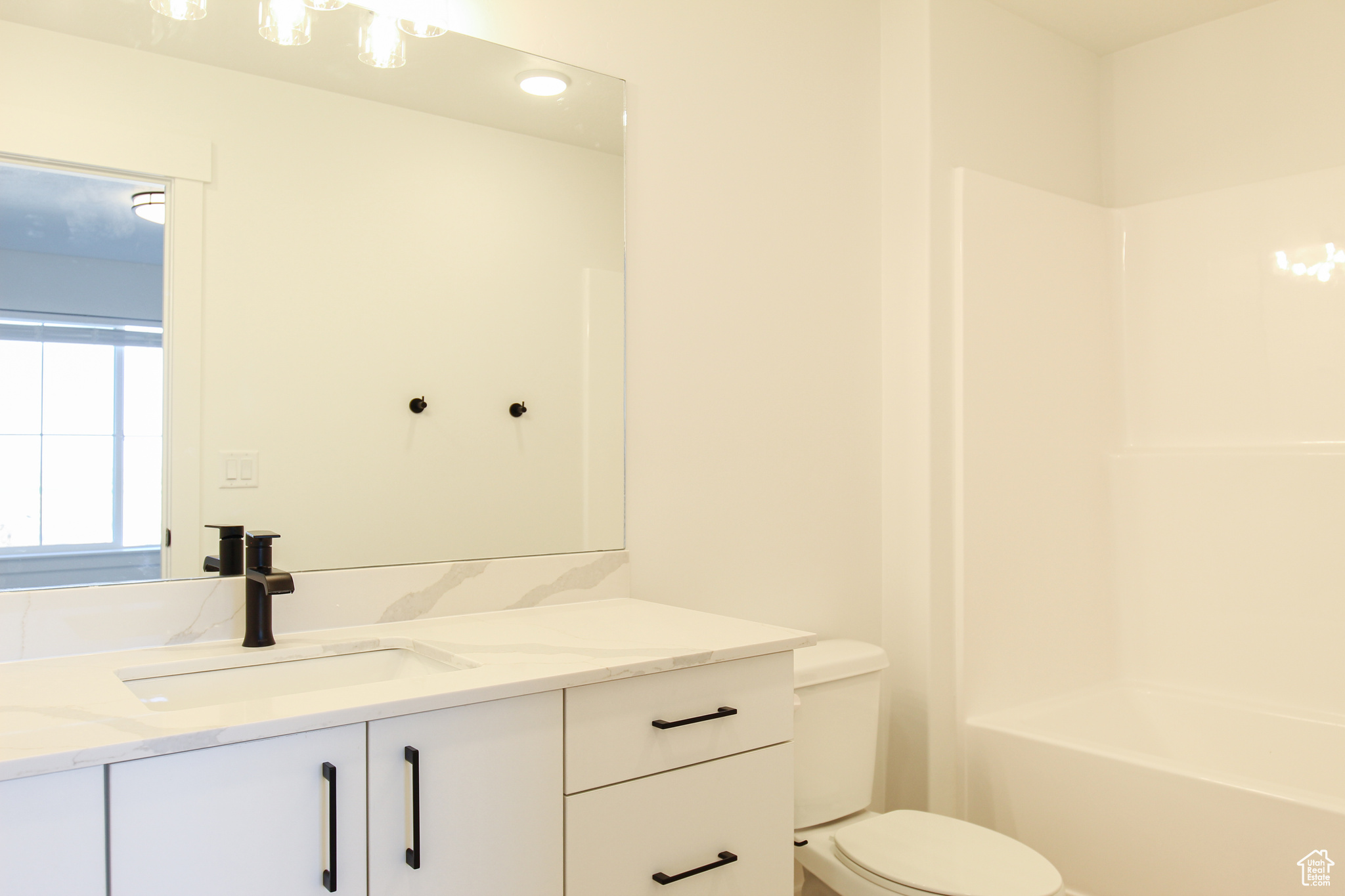 Full bathroom featuring vanity, bathtub / shower combination, and toilet