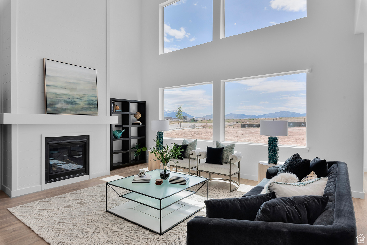 Living room with a mountain view, wood-type flooring, a high ceiling, and a wealth of natural light