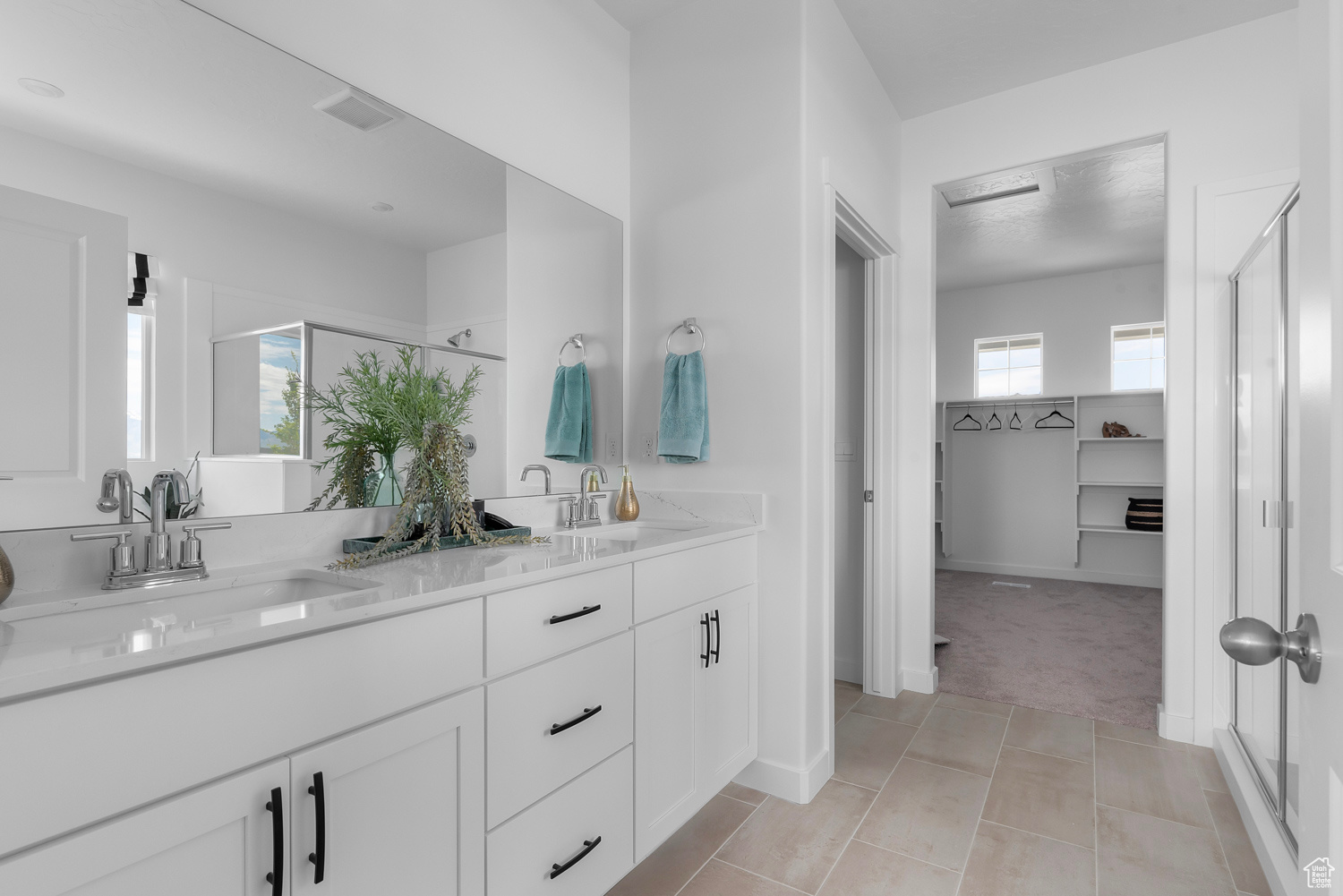 Bathroom featuring tile patterned flooring, vanity, and an enclosed shower