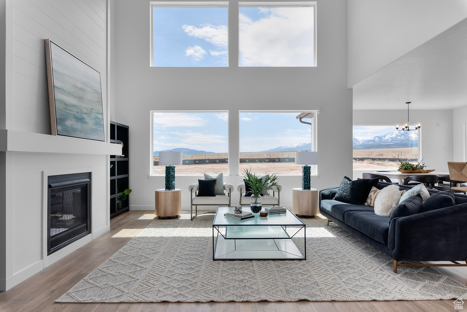 Living room with a mountain view, a high ceiling, a chandelier, and light hardwood / wood-style floors