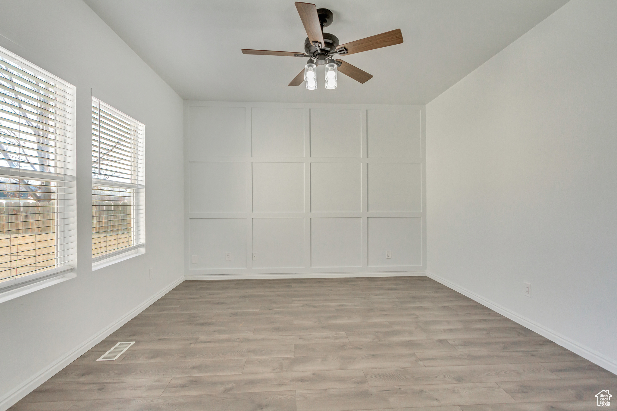 Master bedroom with light wood-type flooring, a wealth of natural light, and ceiling fan