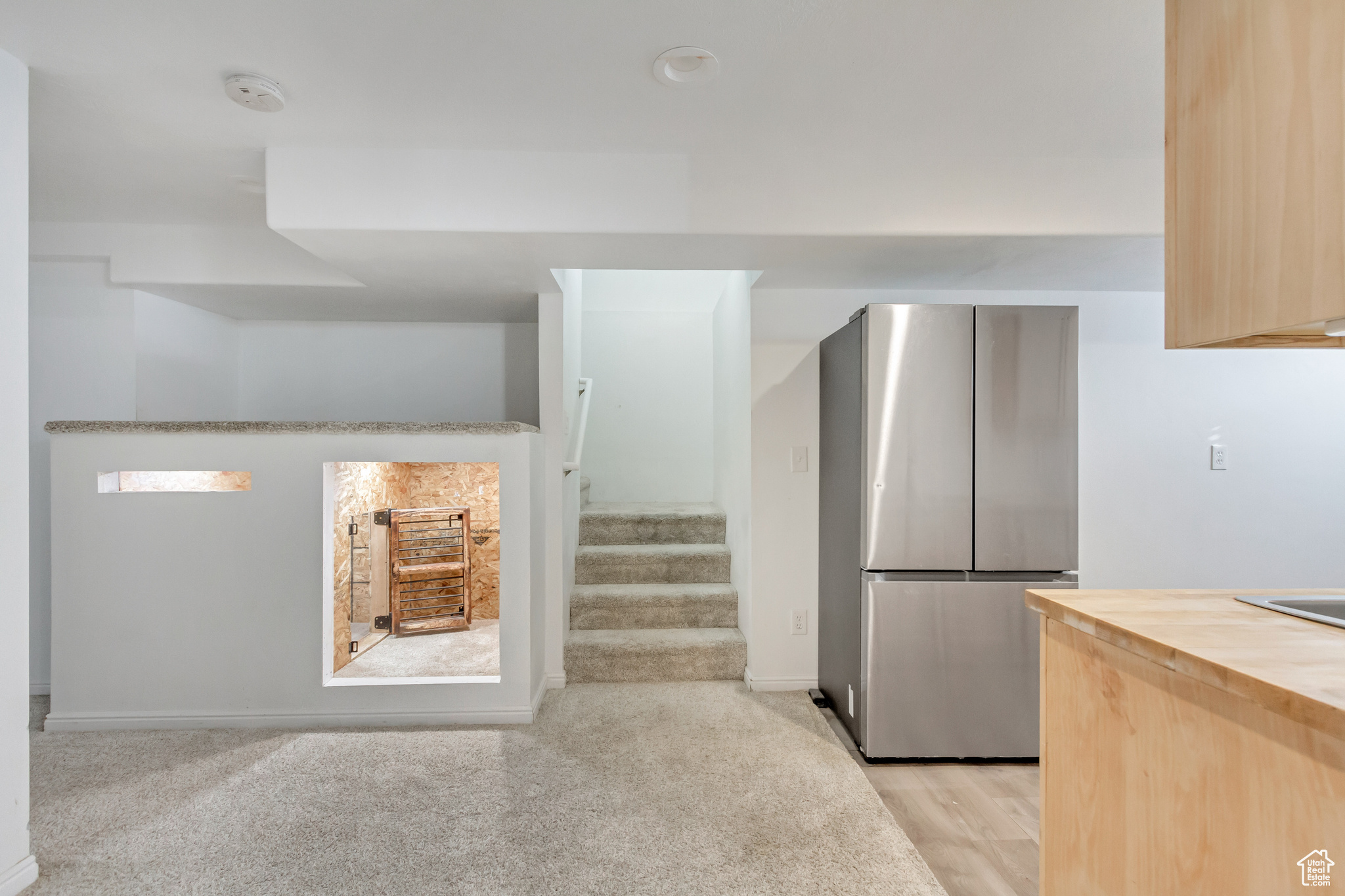 Kitchen with stainless steel fridge and light brown cabinets