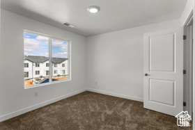 Empty room featuring dark carpet