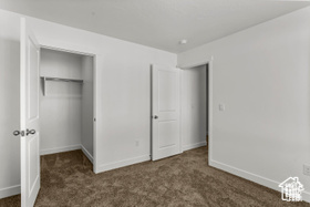 Unfurnished bedroom with dark colored carpet and a closet