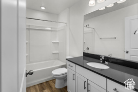 Full bathroom with shower / bath combination, vanity, toilet, and wood-type flooring