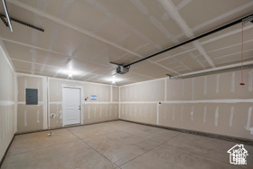 Garage featuring a garage door opener and electric panel