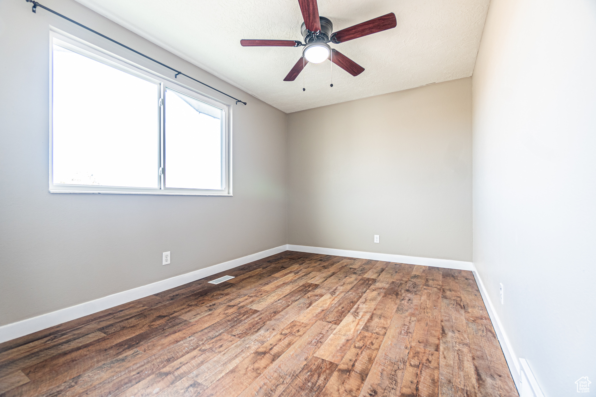 Spare room with hardwood / wood-style floors and ceiling fan