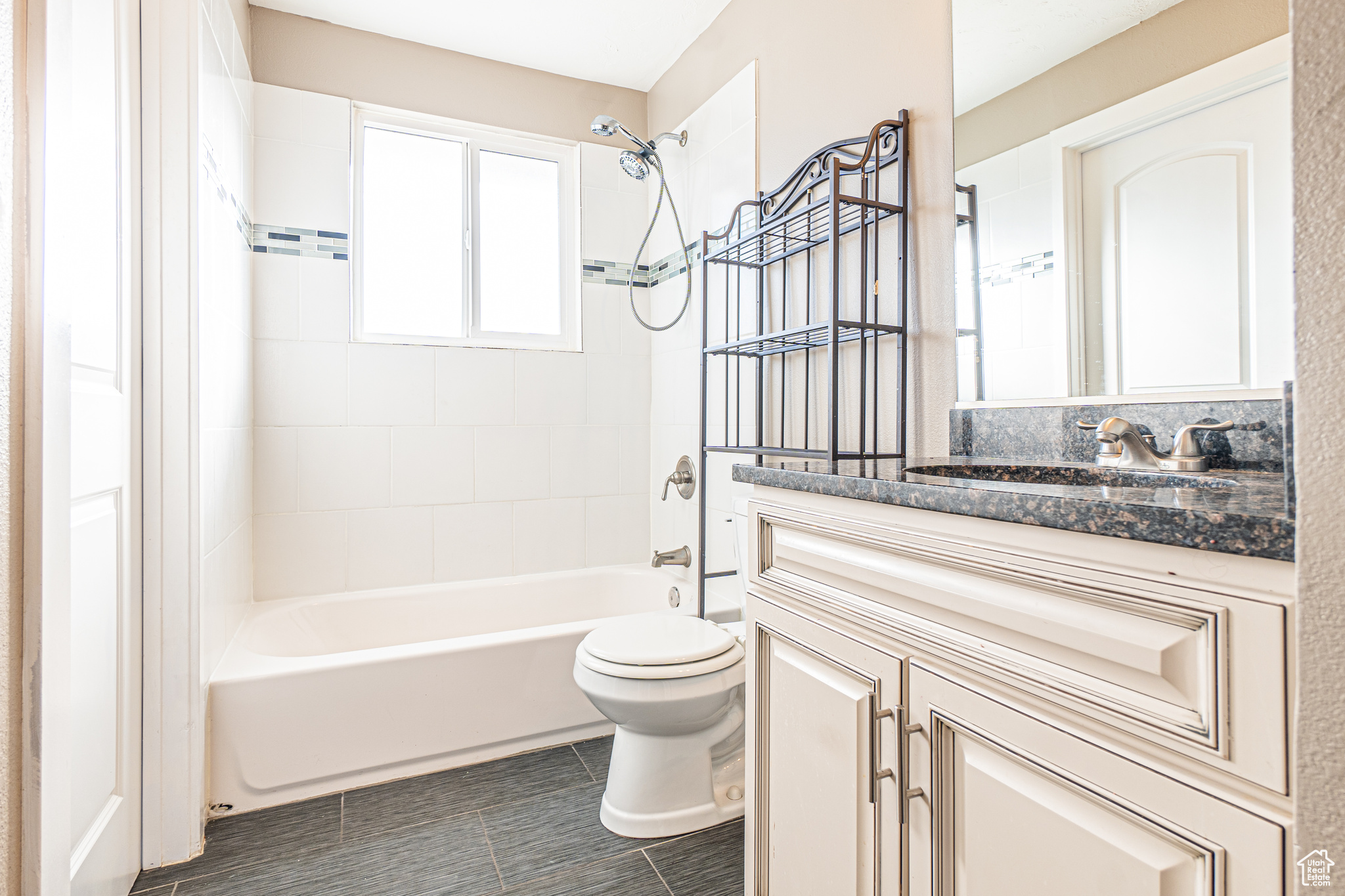 Full bathroom featuring toilet, tile patterned flooring, vanity, and tiled shower / bath