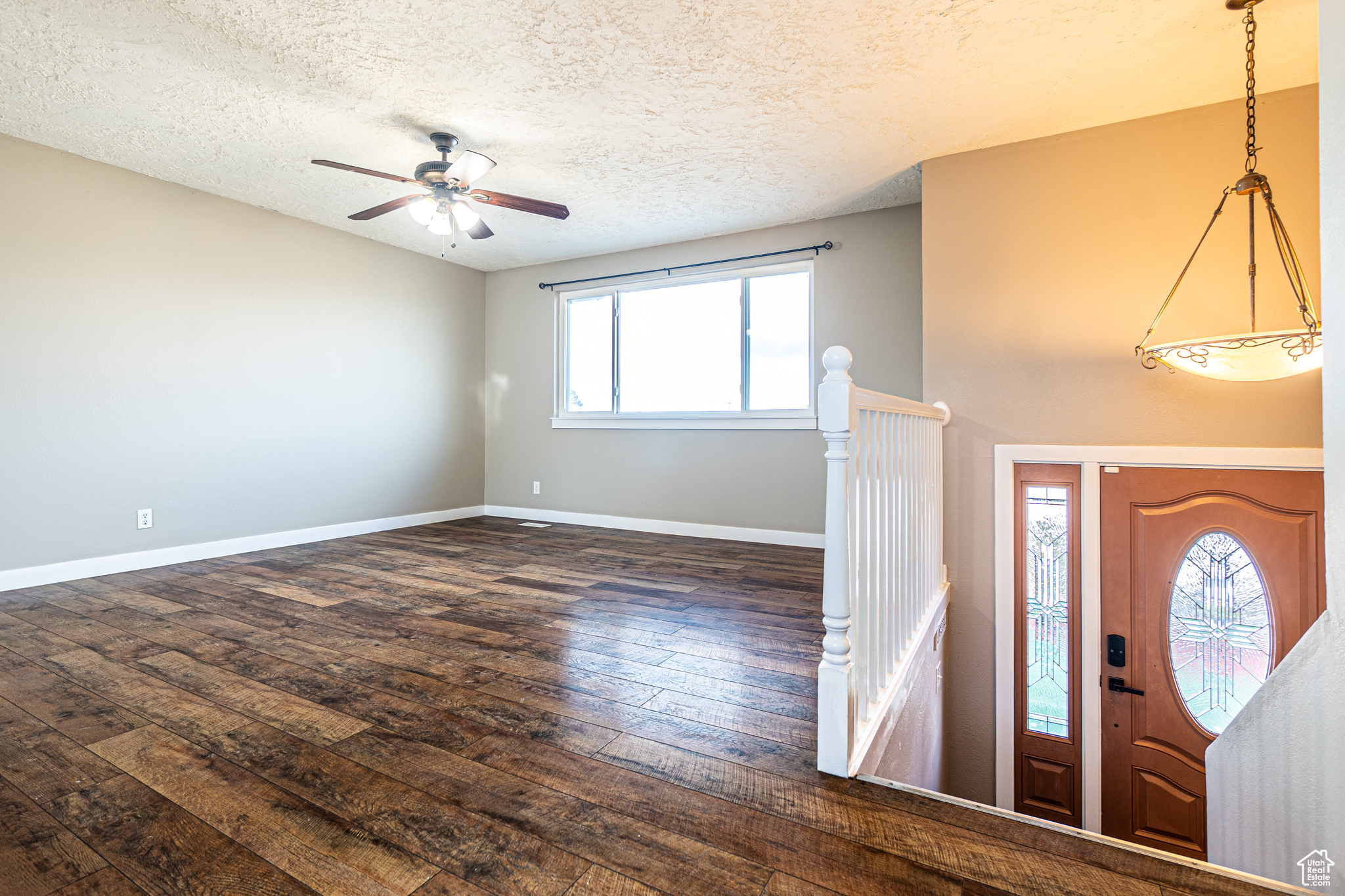 Foyer featuring a healthy amount of sunlight, ceiling fan, dark hardwood / wood-style floors, and a textured ceiling