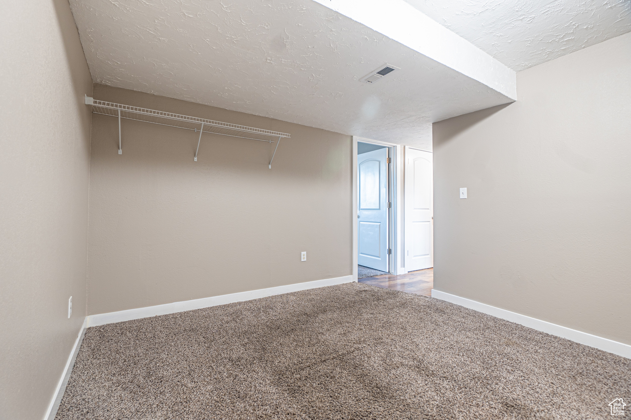 Interior space featuring carpet and a textured ceiling