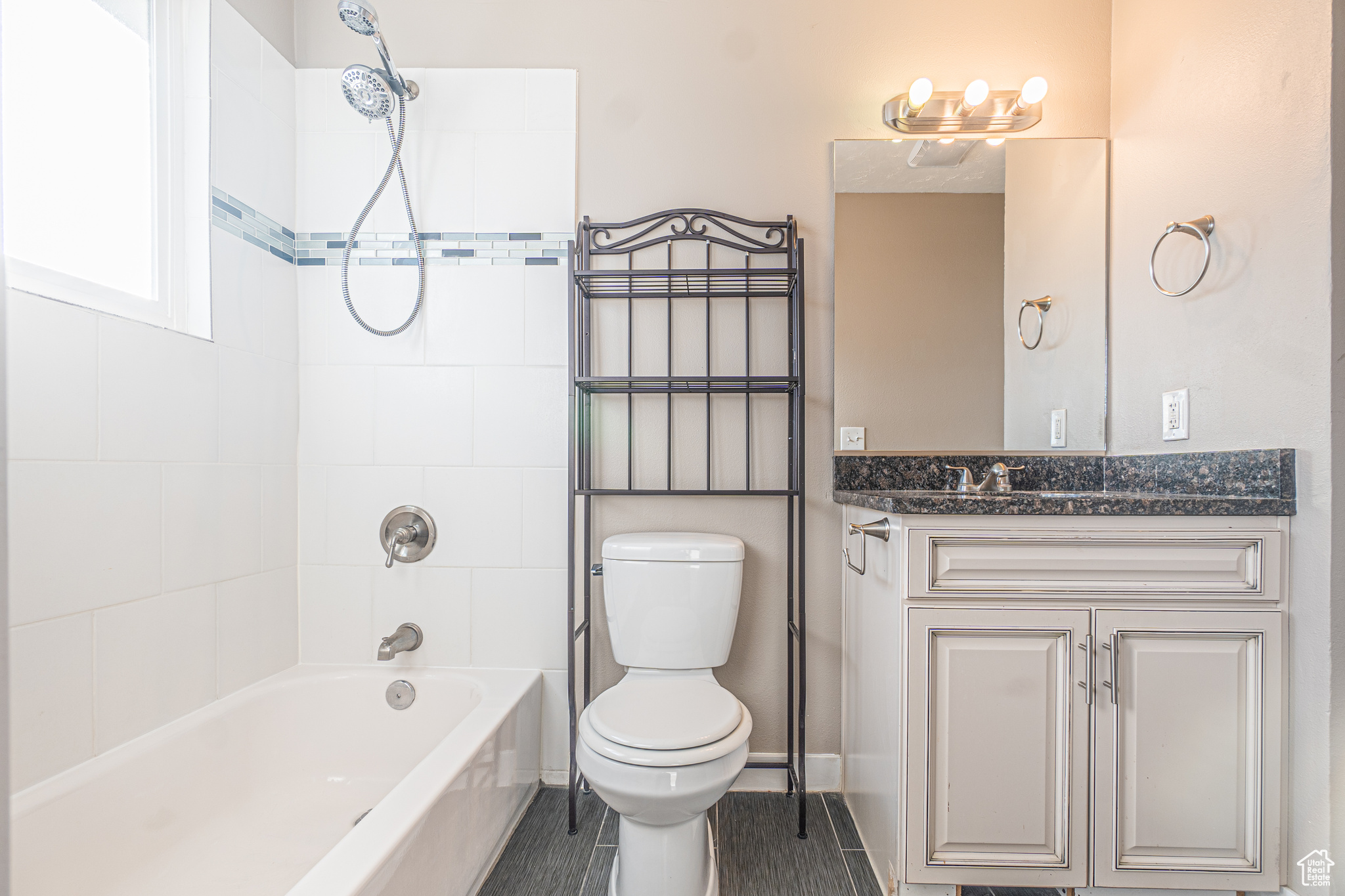 Full bathroom with toilet, vanity, and tiled shower / bath