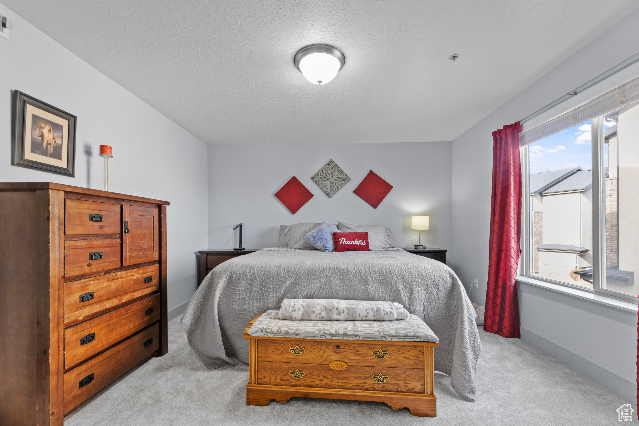 Bedroom featuring light colored carpet and a textured ceiling