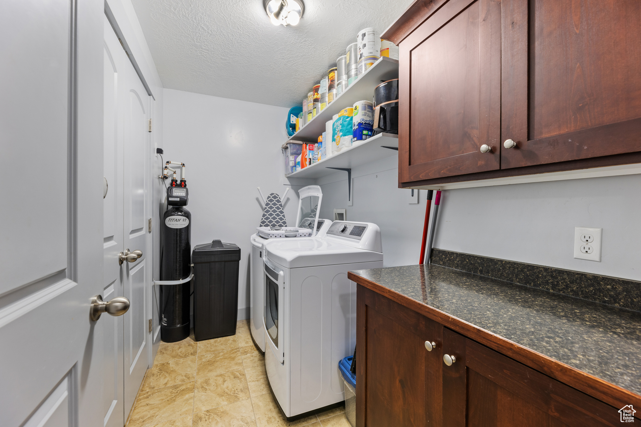 Laundry area with cabinets, separate washer and dryer, and a textured ceiling