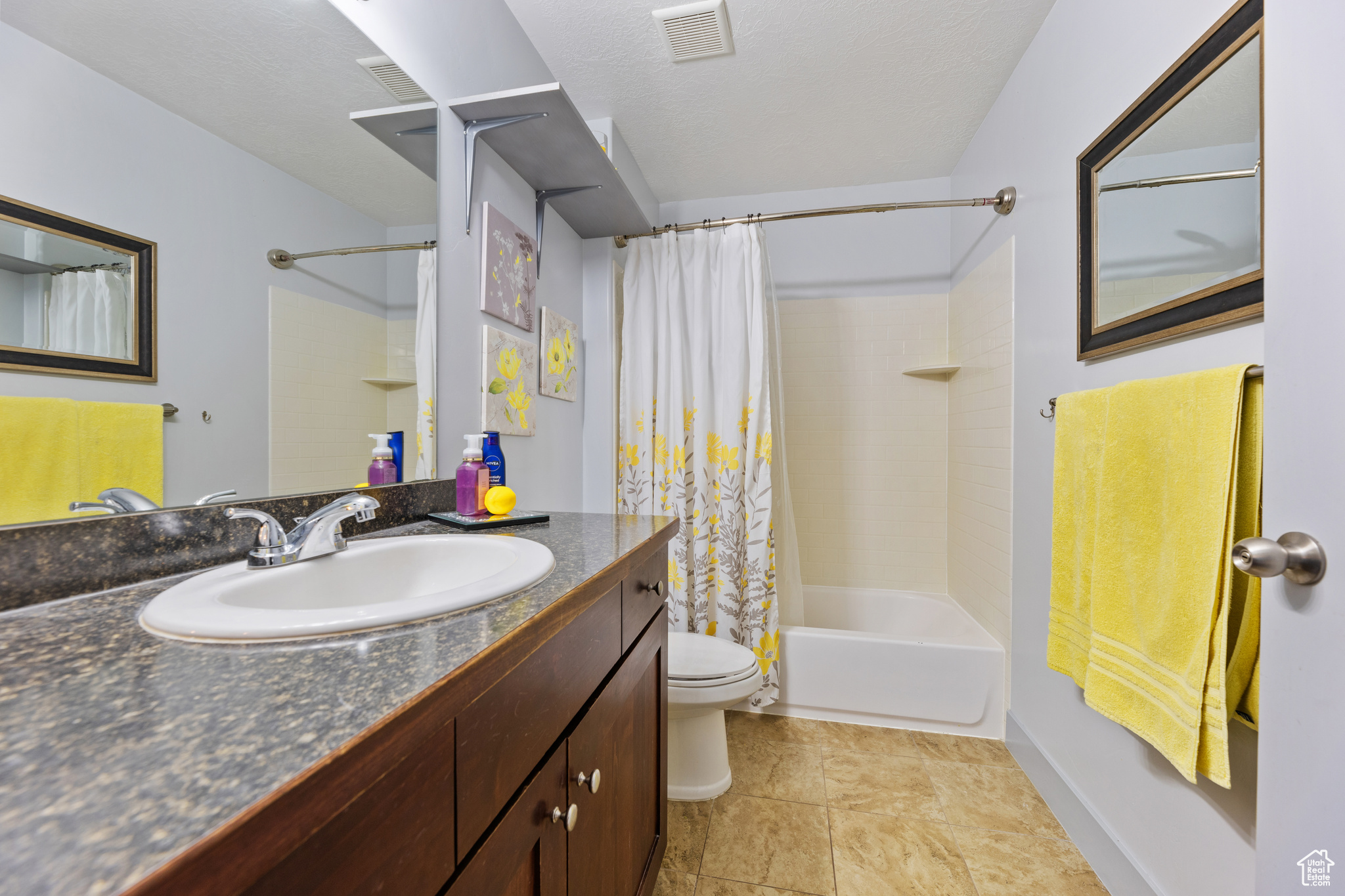 Full bathroom with shower / bath combo with shower curtain, vanity, and toilet