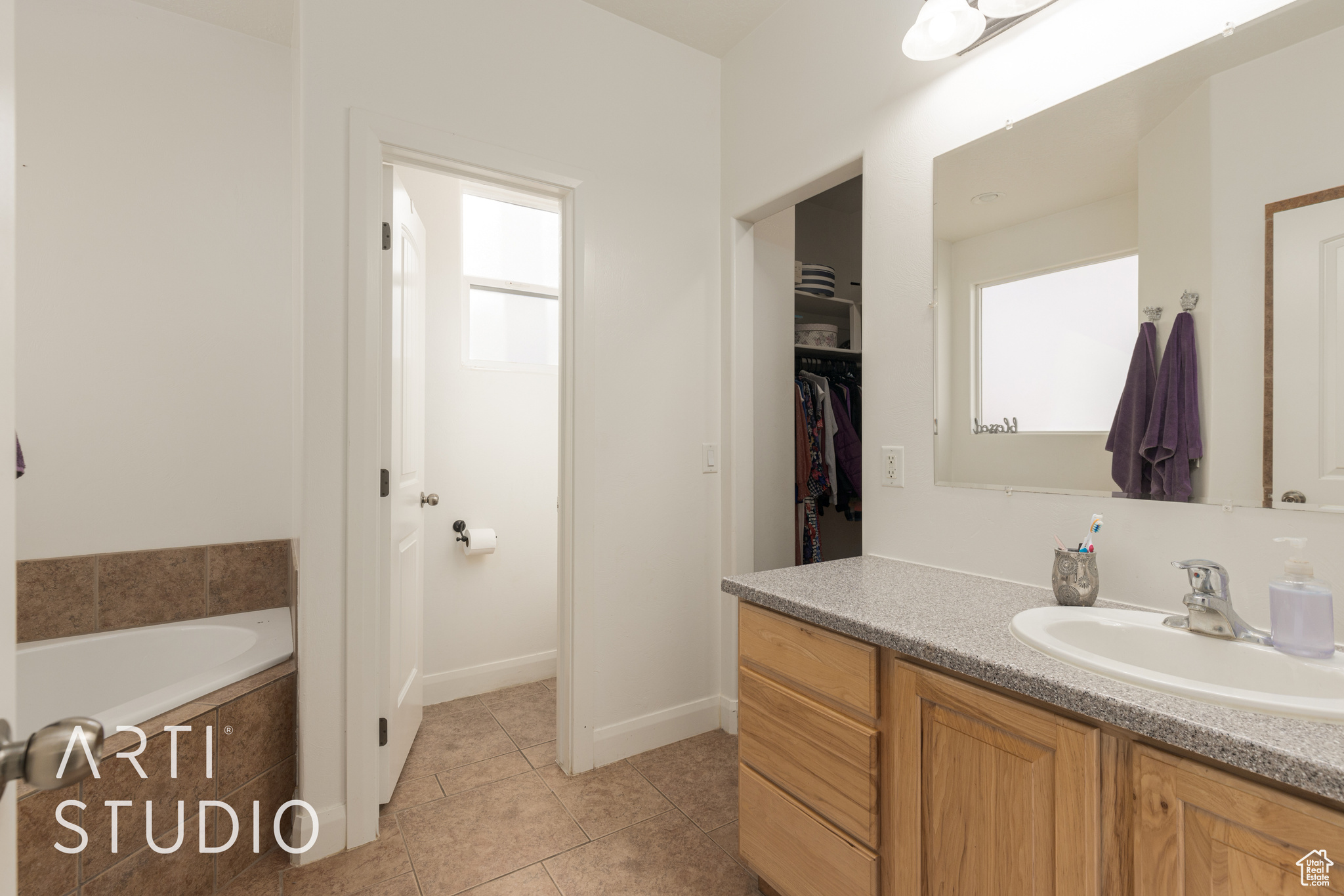 Bathroom featuring a bathing tub, tile patterned flooring, and vanity