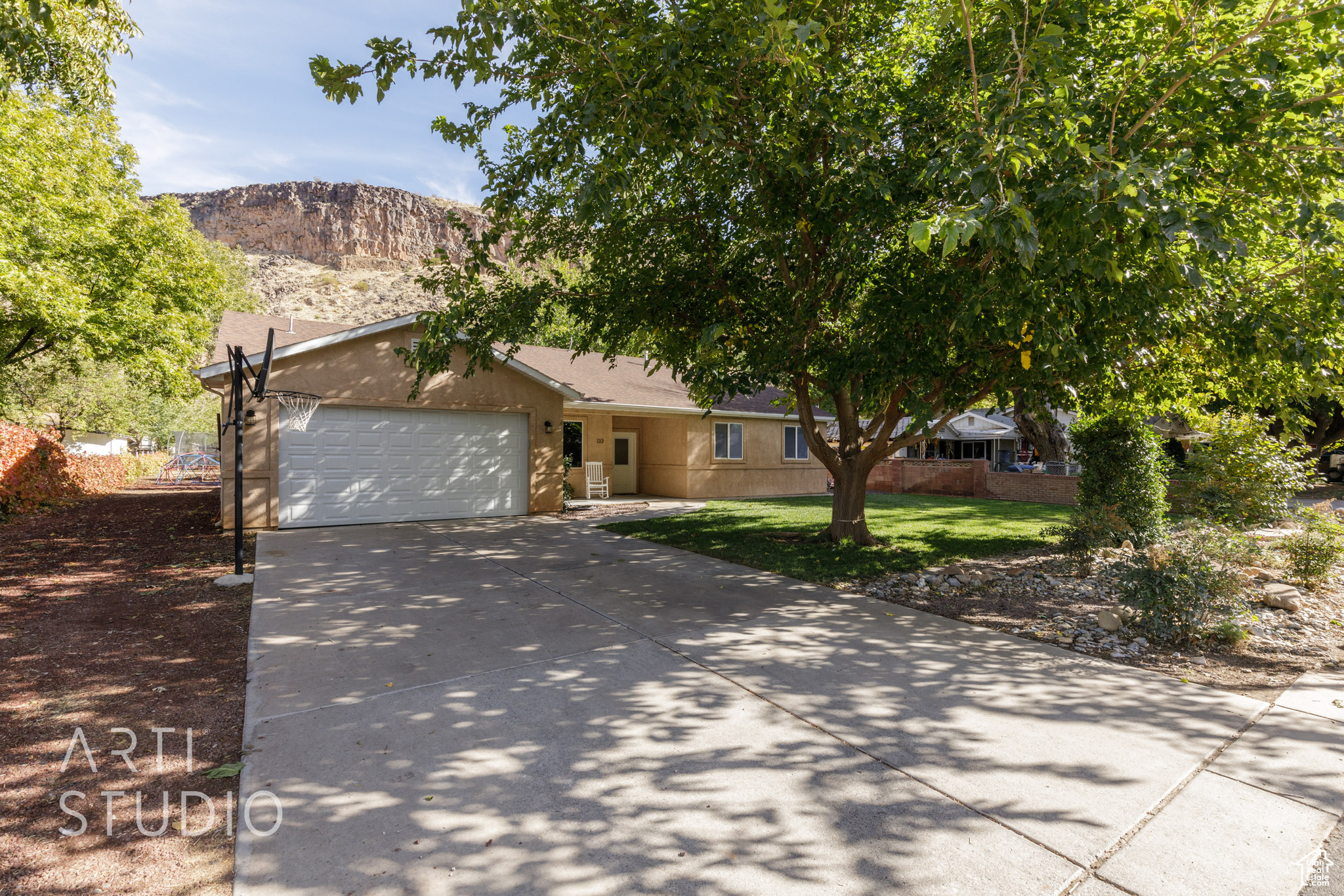 View of front facade featuring a mountain view, a front yard, and a garage