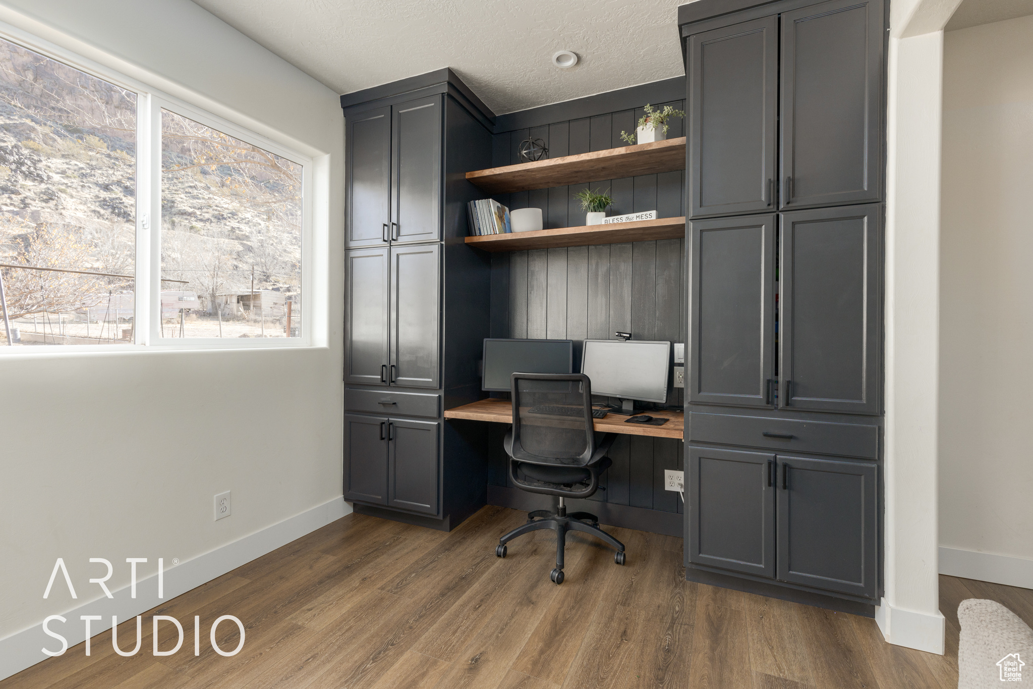 Office area with dark hardwood / wood-style floors and built in desk