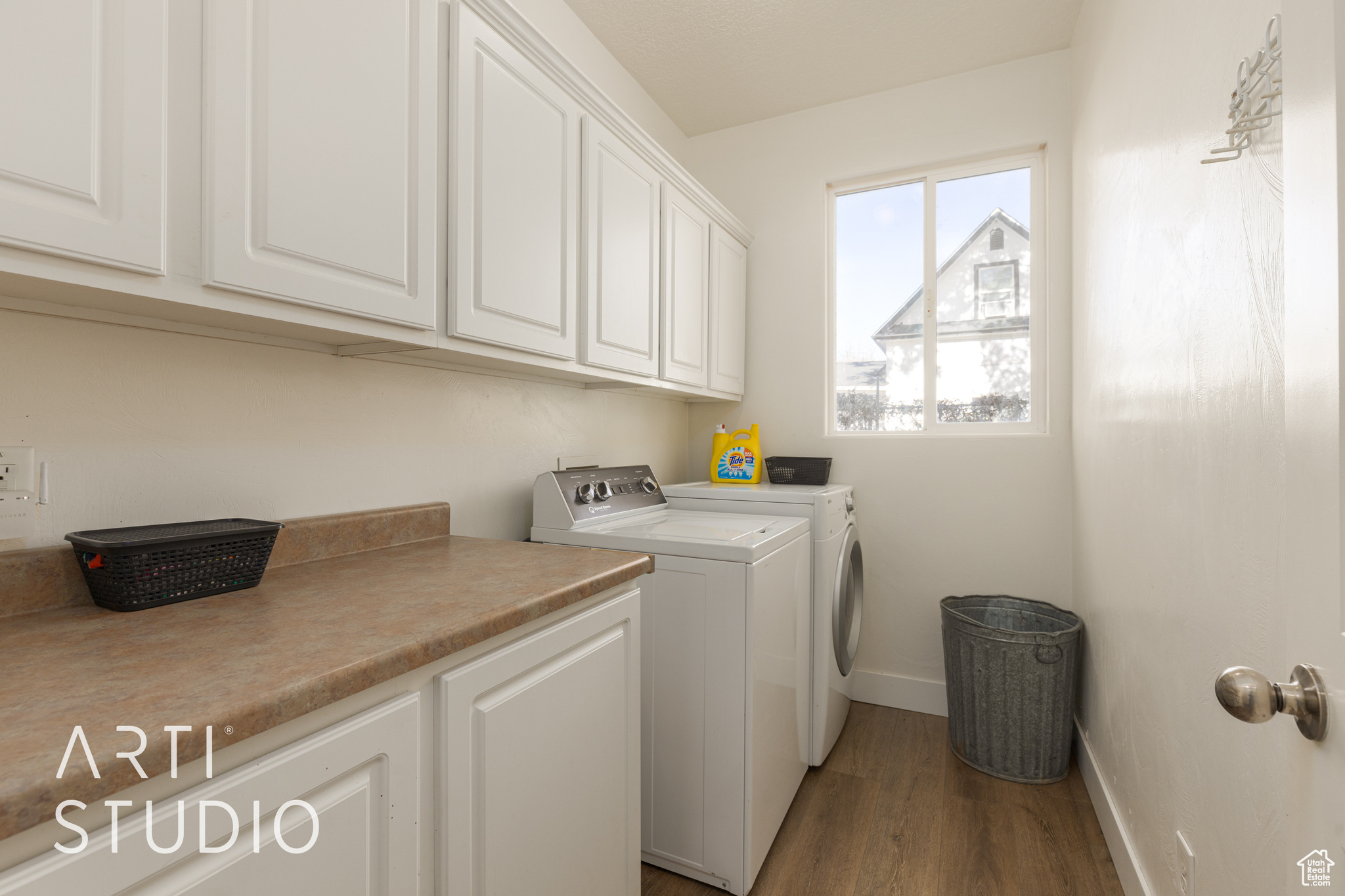 Laundry area with separate washer and dryer, dark hardwood / wood-style flooring, and cabinets