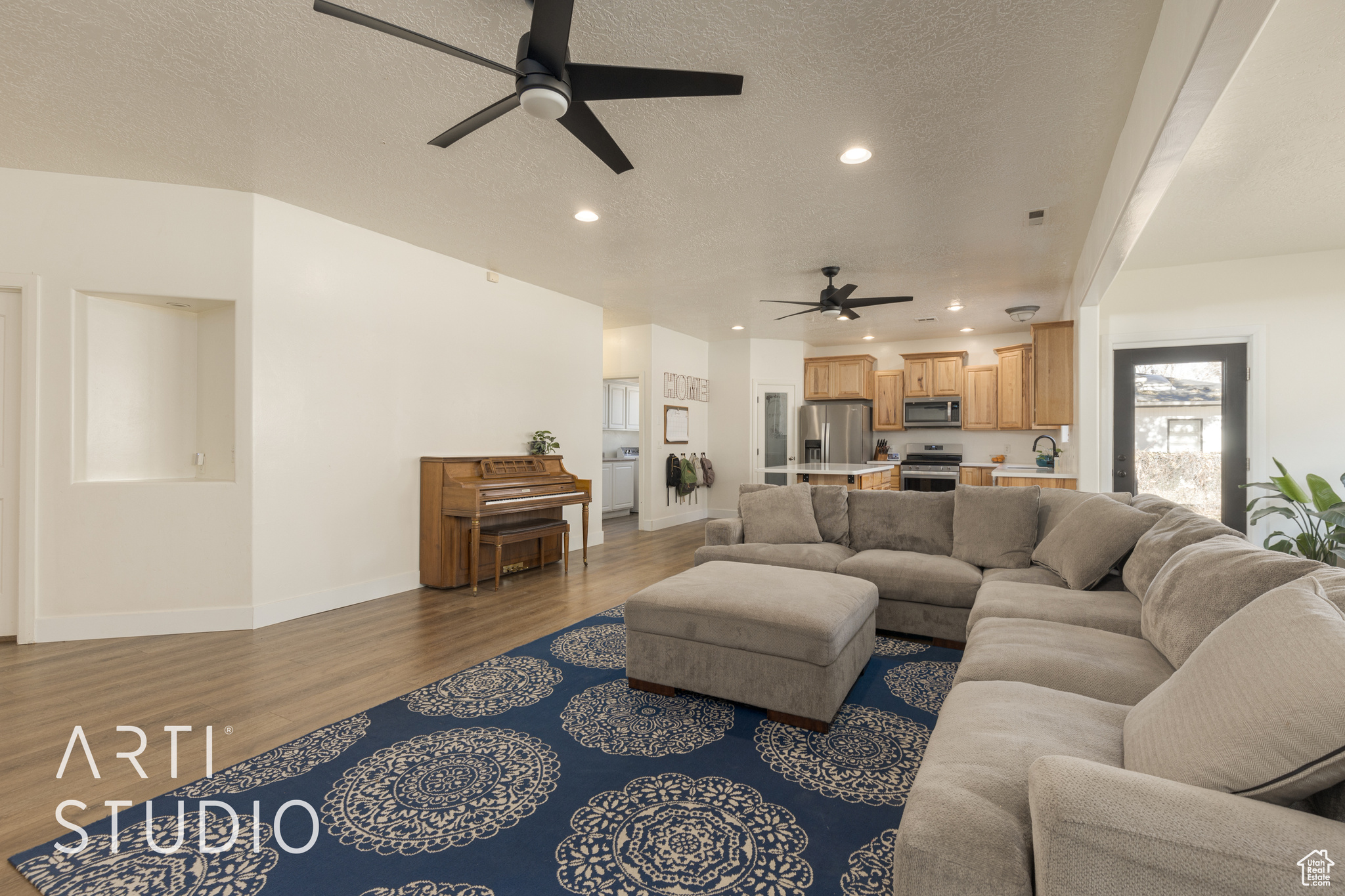 Living room with sink, ceiling fan, dark hardwood / wood-style flooring, and a textured ceiling