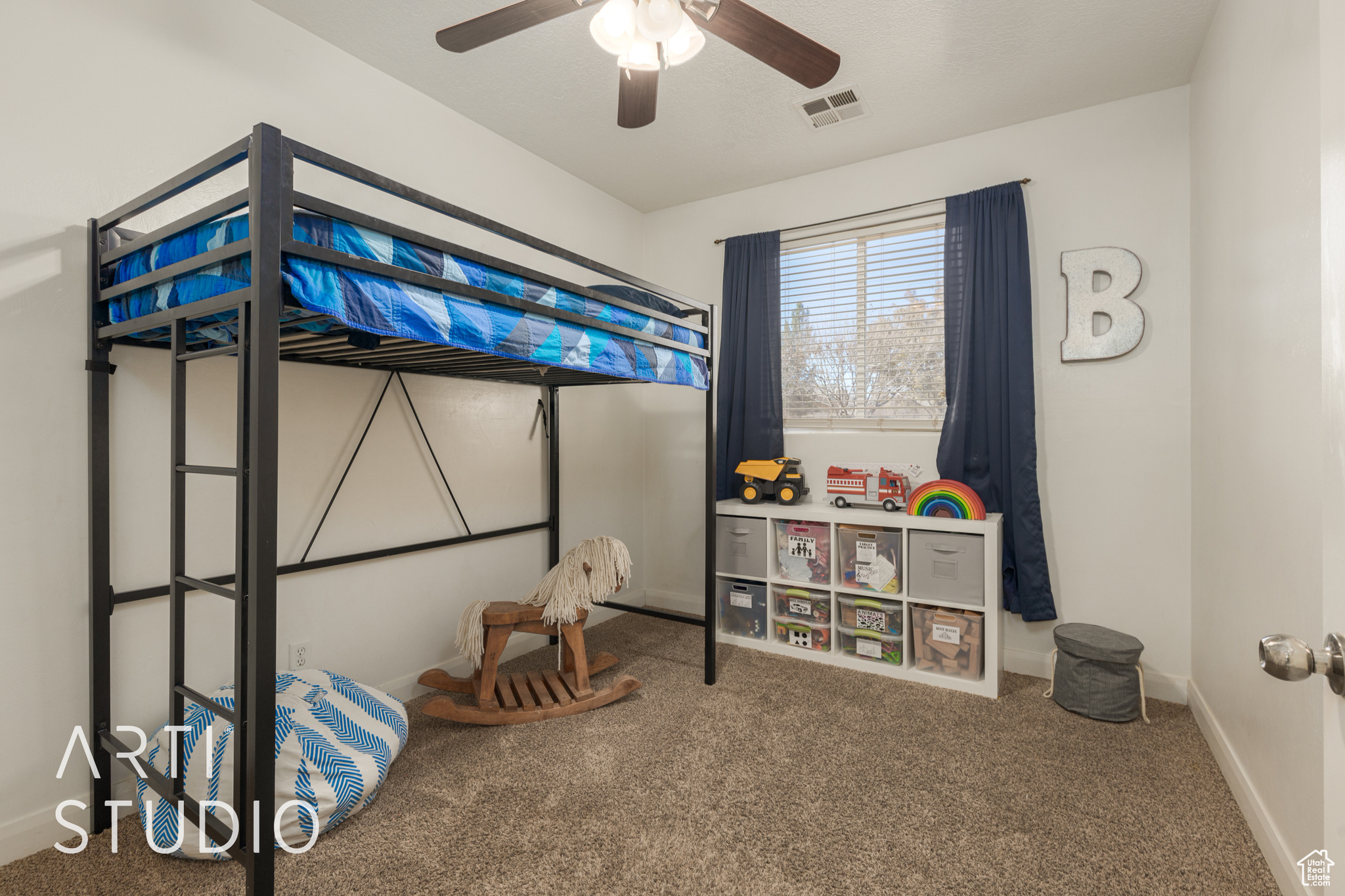 Carpeted bedroom featuring ceiling fan