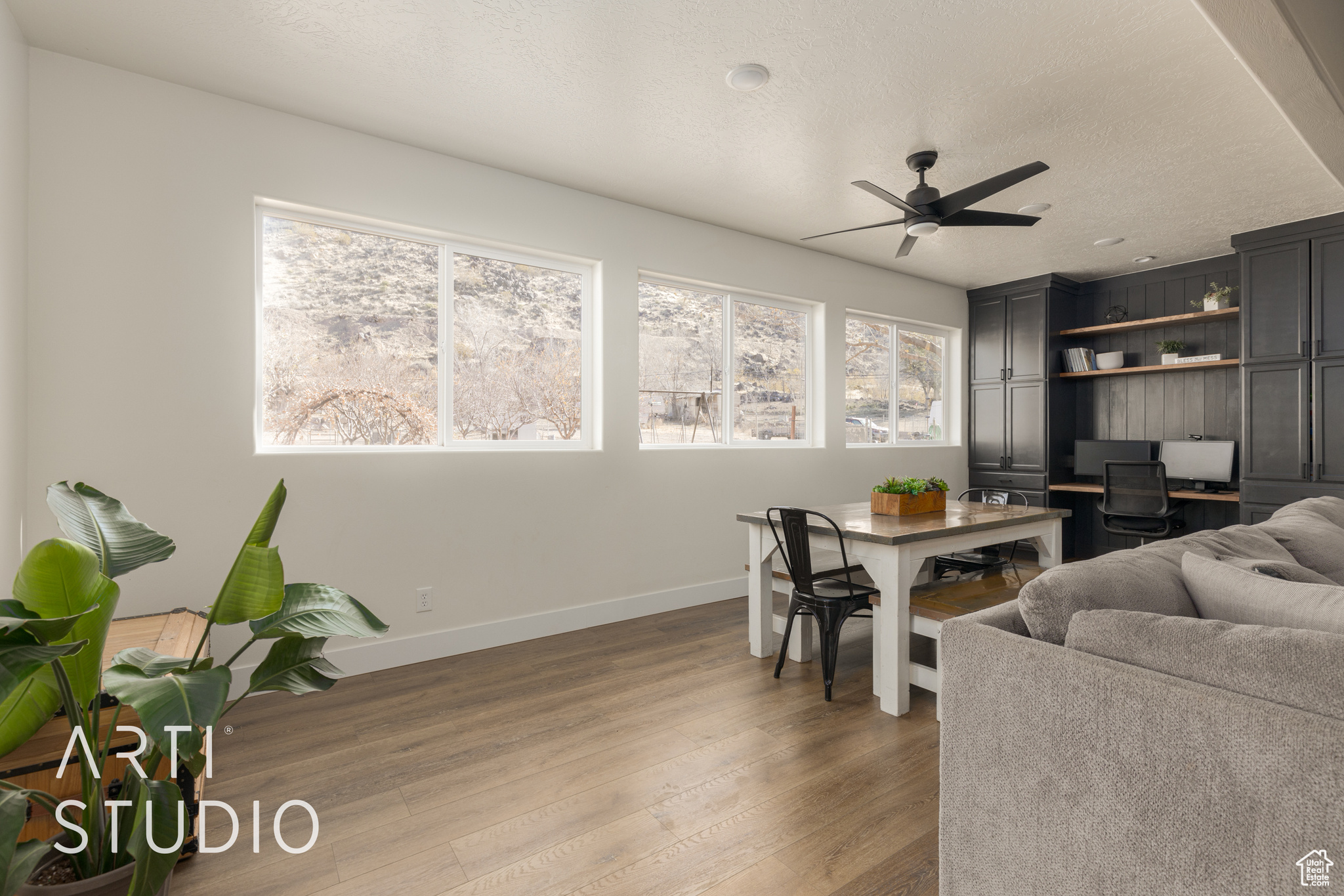 Living room featuring ceiling fan, a textured ceiling, and hardwood / wood-style flooring