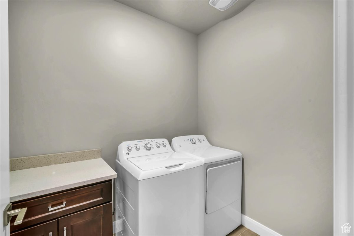 Washroom featuring cabinets and independent washer and dryer