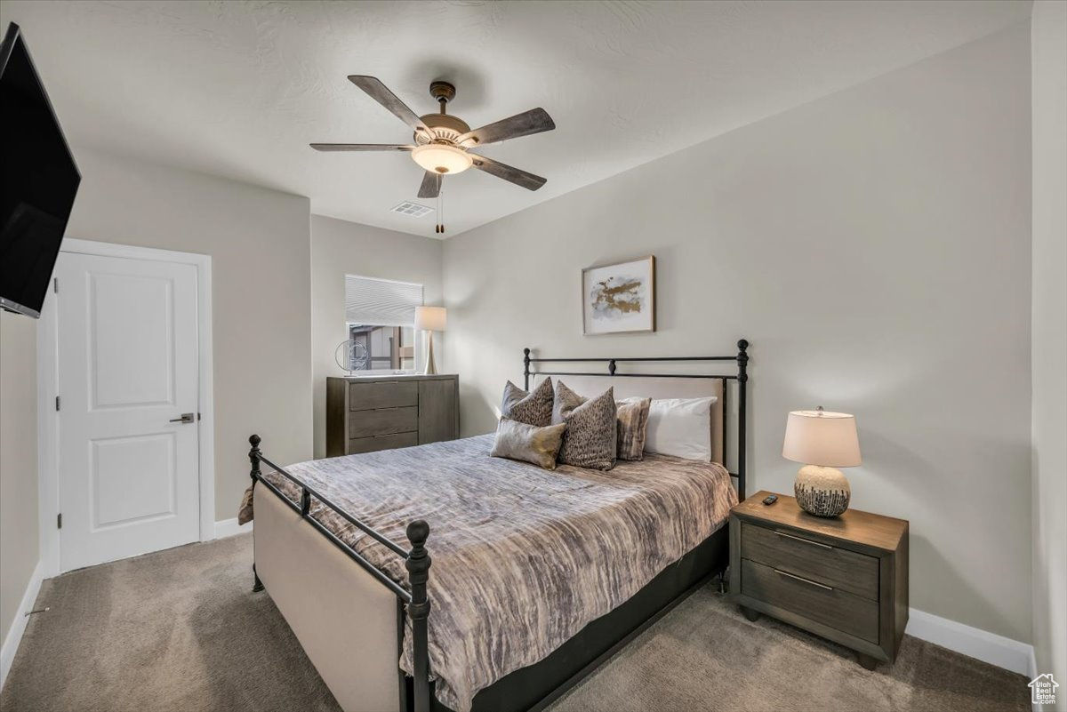 Carpeted bedroom featuring ceiling fan