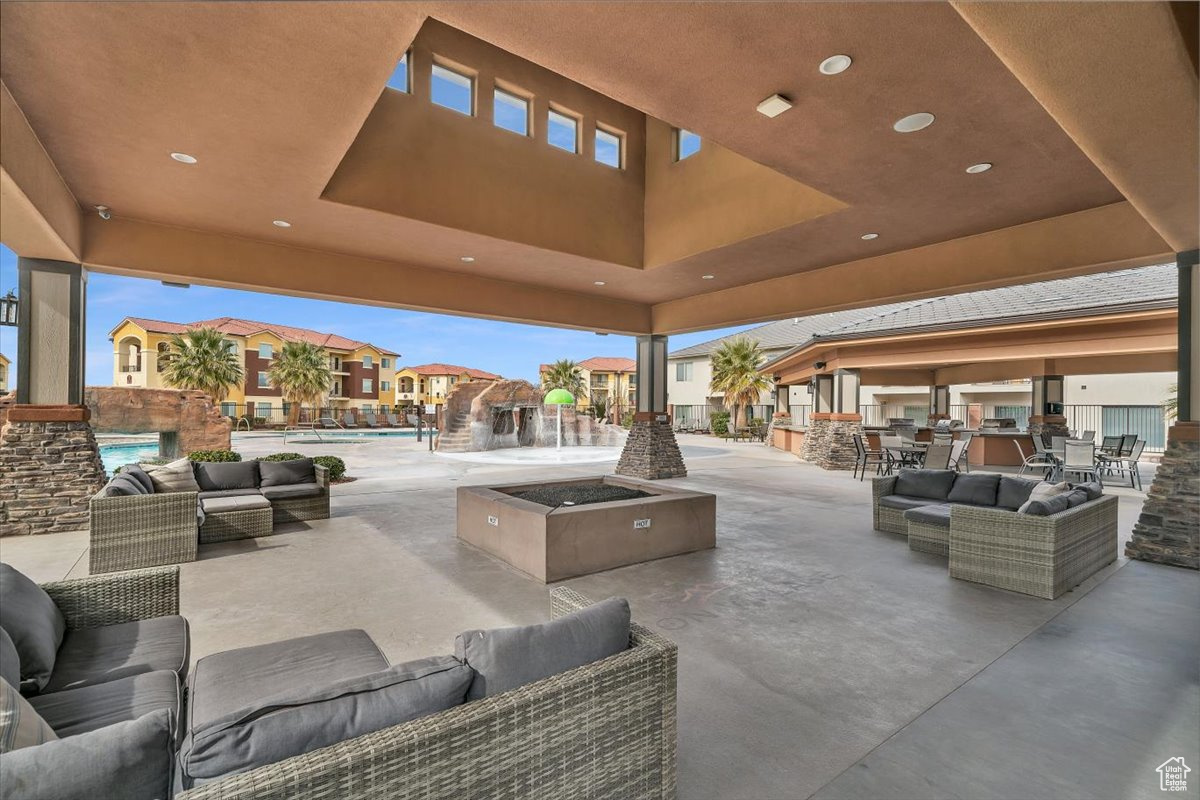 View of patio with pool water feature, a community pool, and an outdoor hangout area