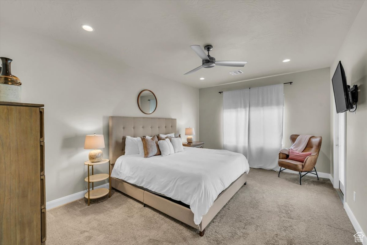 Carpeted bedroom featuring ceiling fan