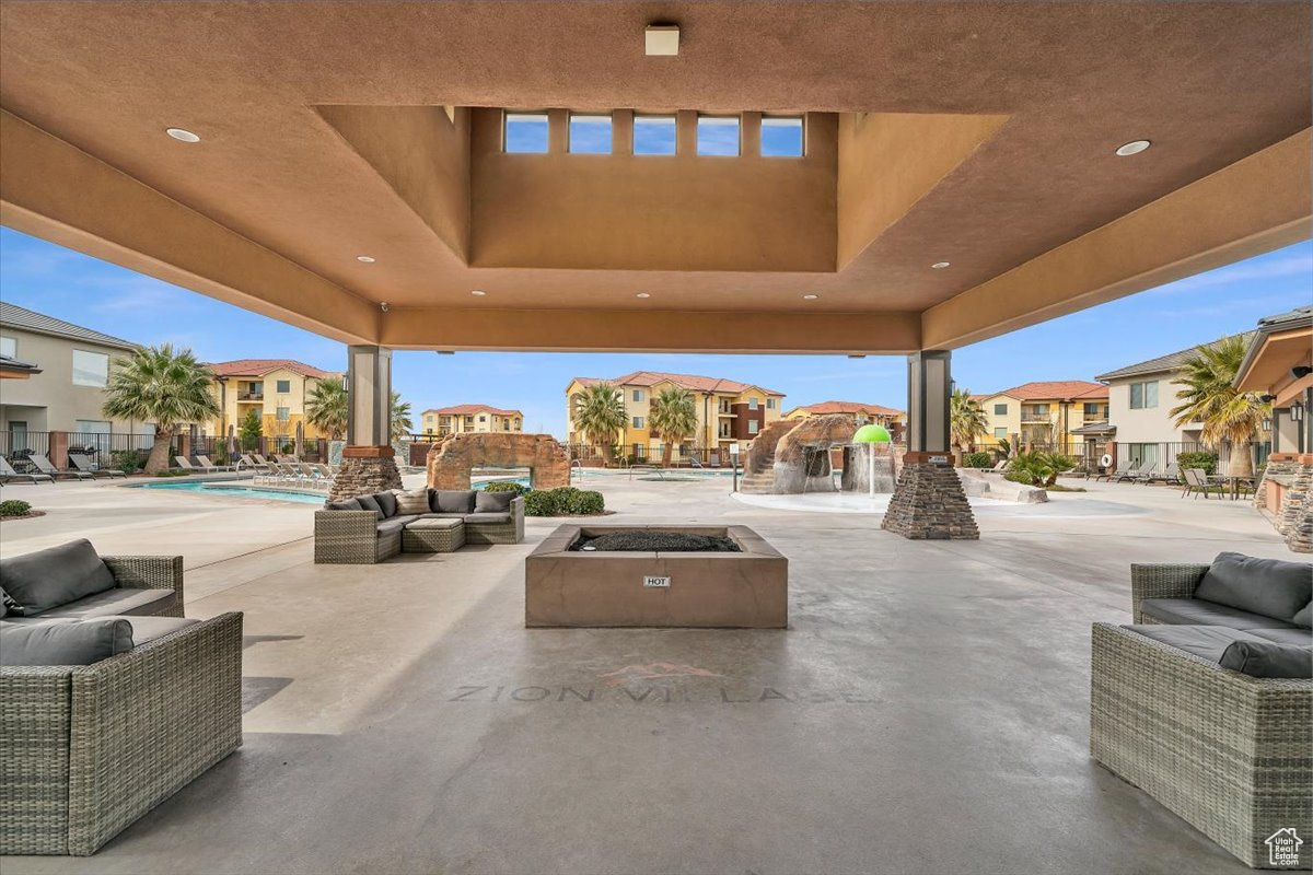 View of patio featuring a community pool and an outdoor living space with a fire pit