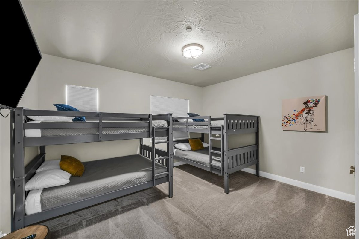 Bedroom featuring carpet flooring and a textured ceiling