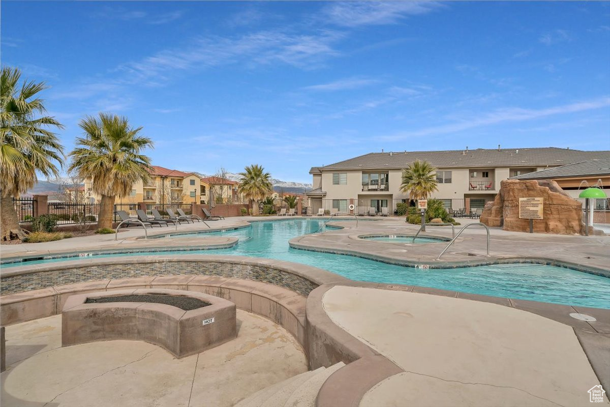 View of pool featuring a hot tub and a patio area