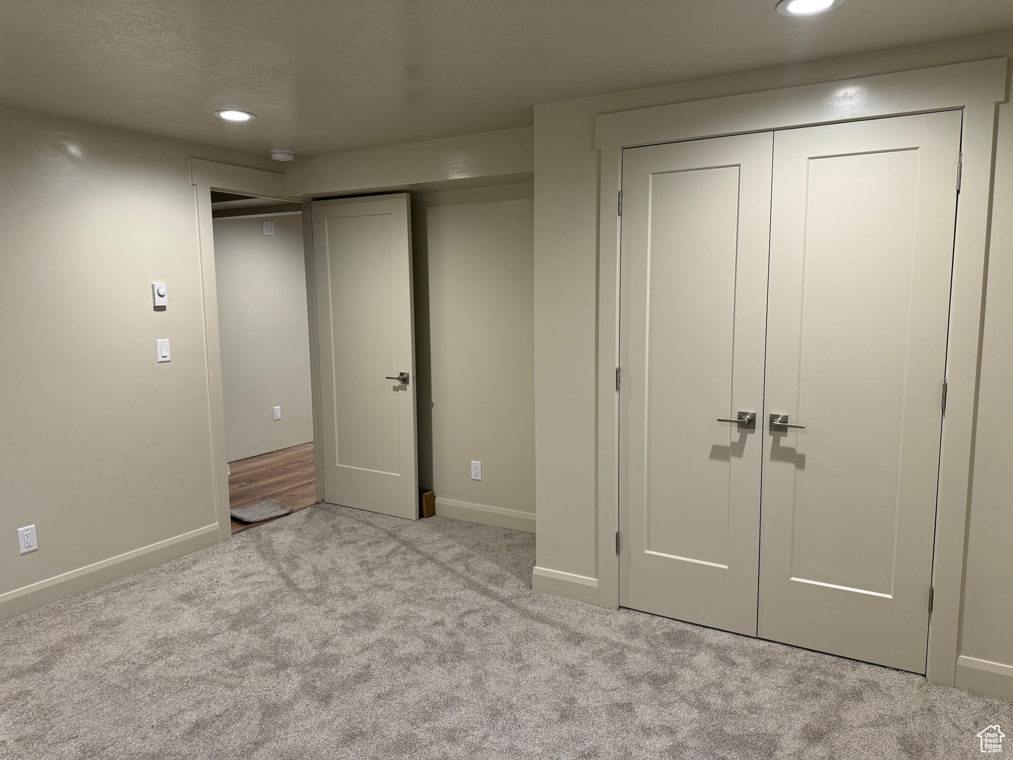 Unfurnished bedroom with light colored carpet