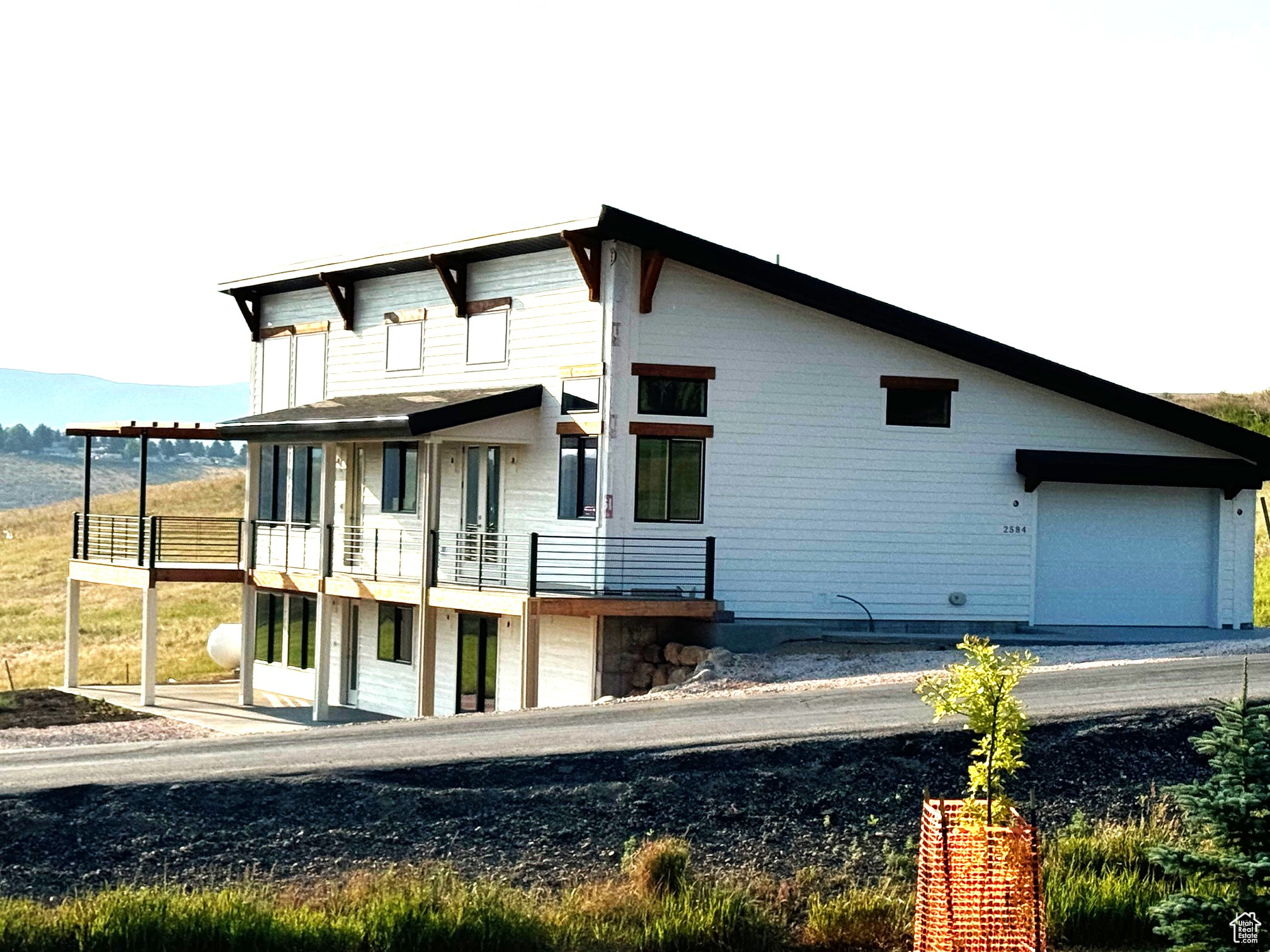 Back of property featuring a garage and a balcony