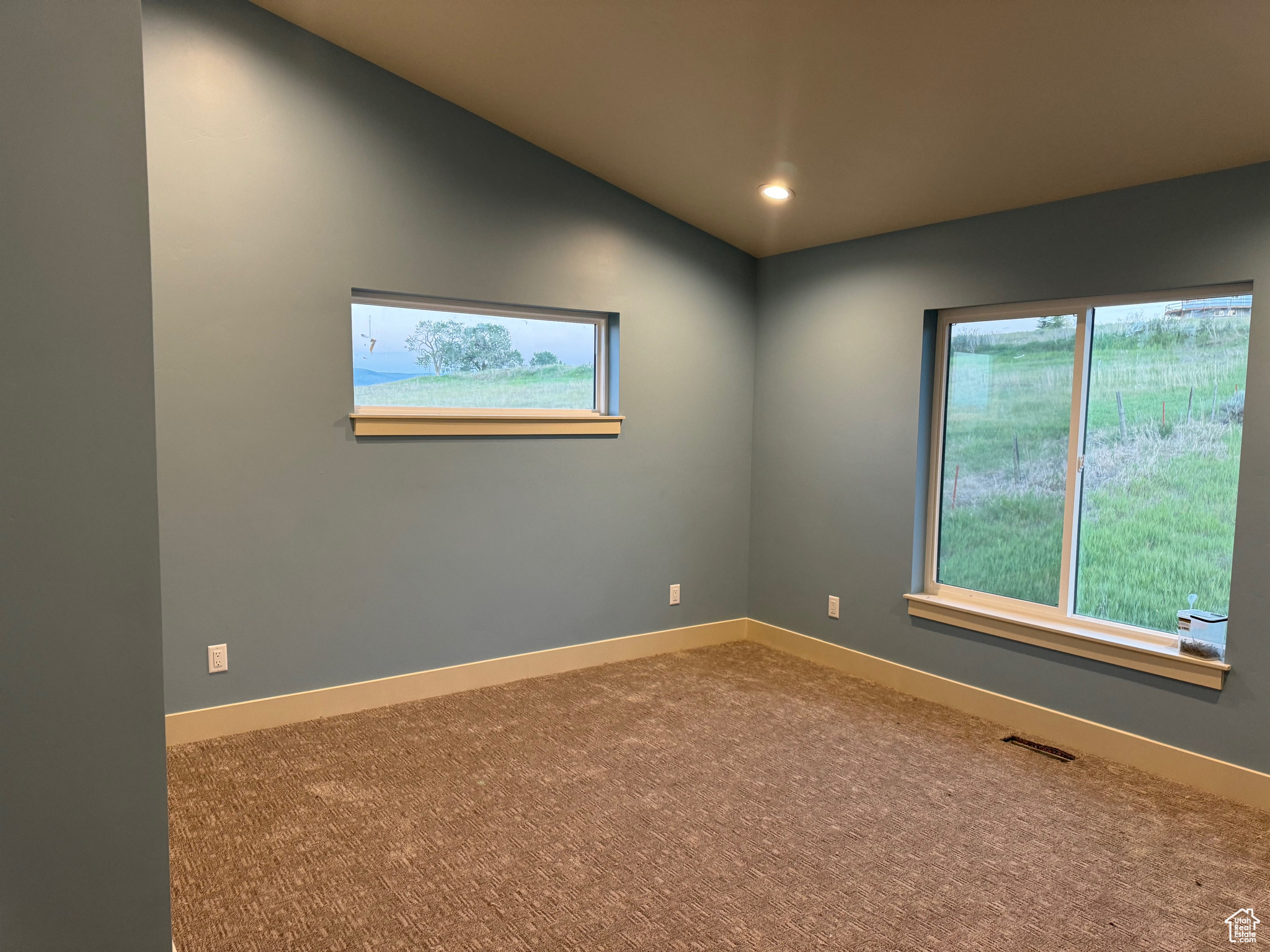 Spare room with carpet floors and vaulted ceiling