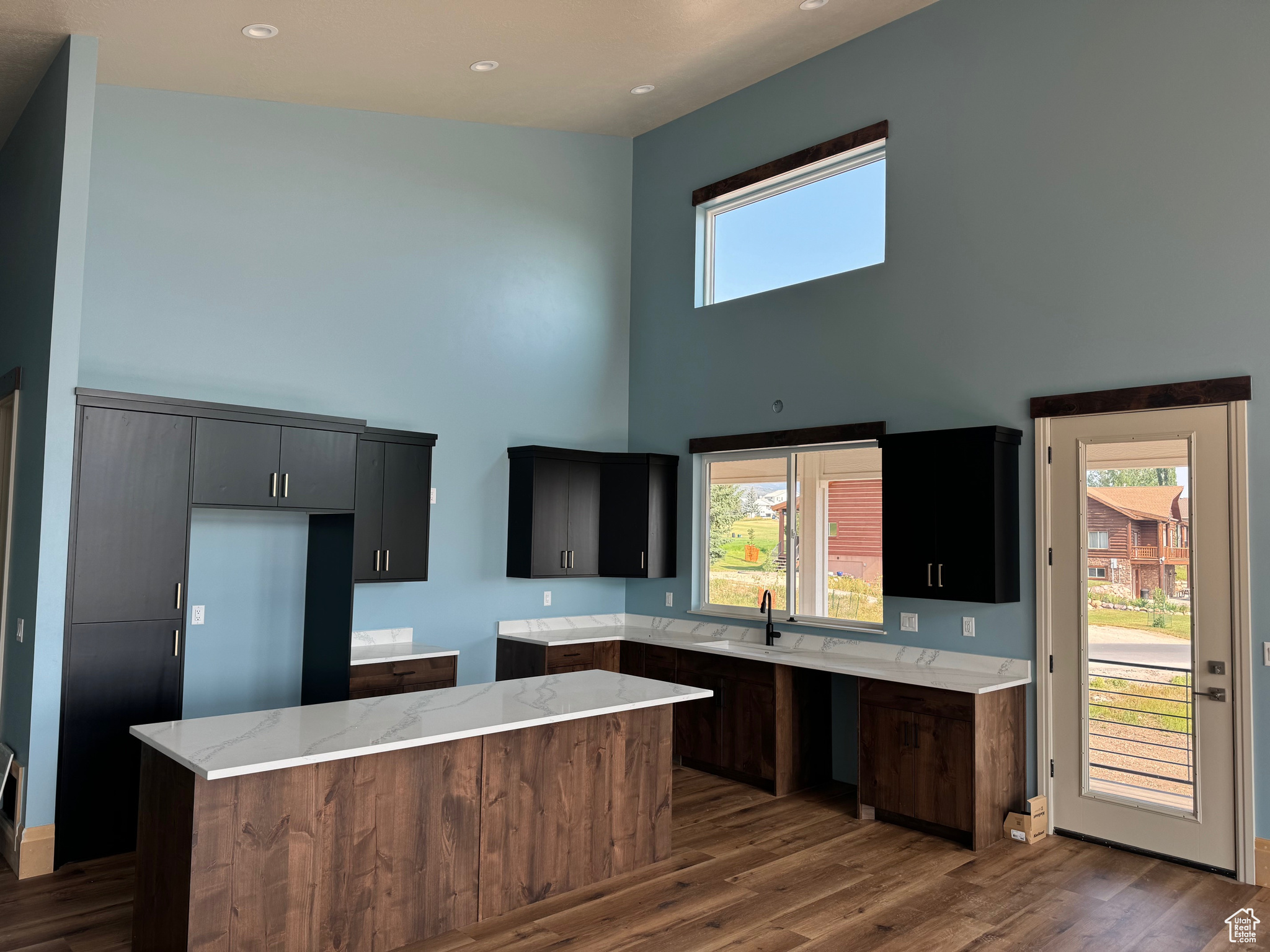 Kitchen with a high ceiling, a center island, and plenty of natural light