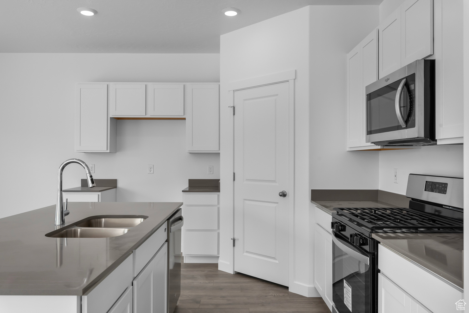 Kitchen with white cabinetry, sink, and stainless steel appliances