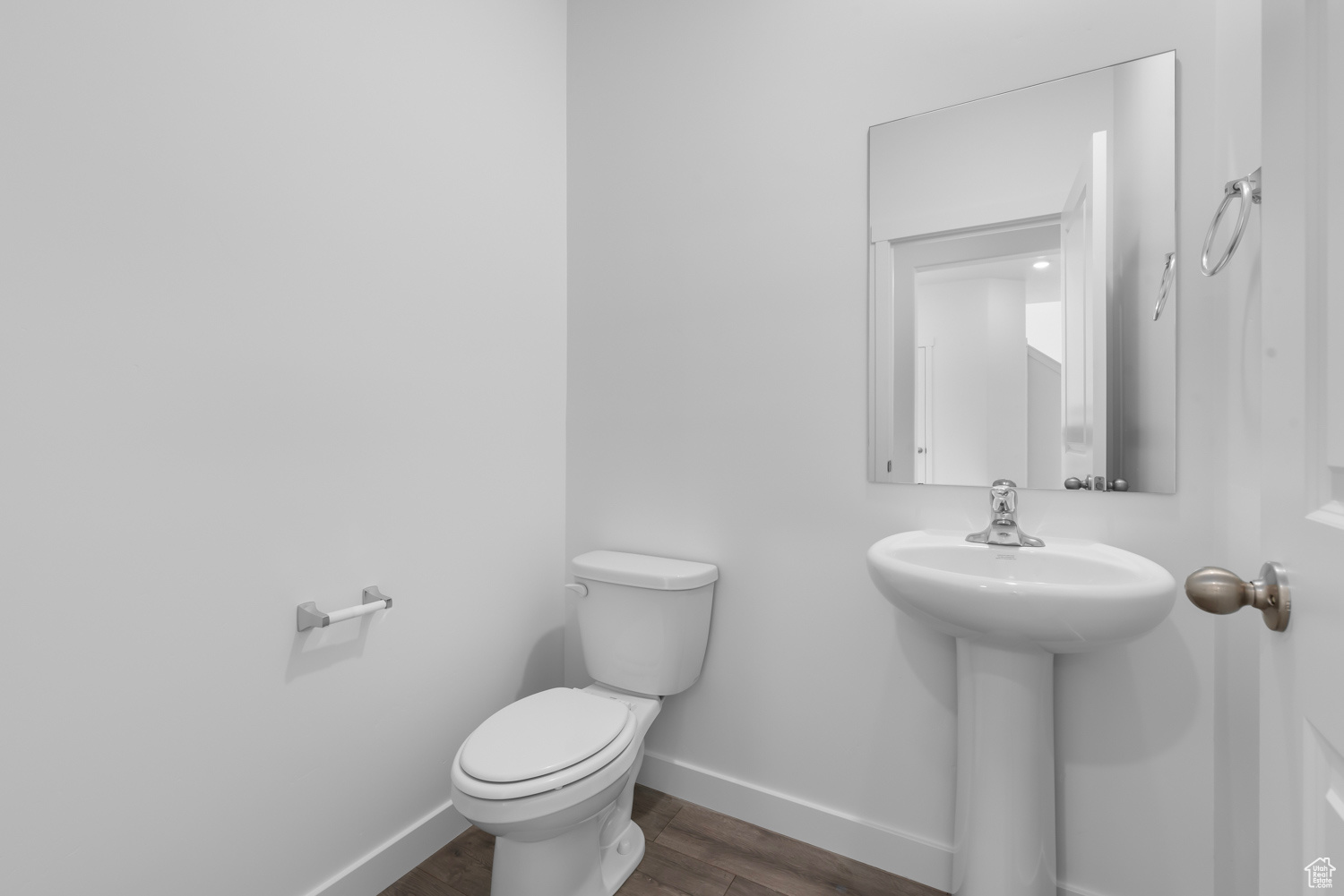 Bathroom featuring toilet, wood-type flooring, and sink