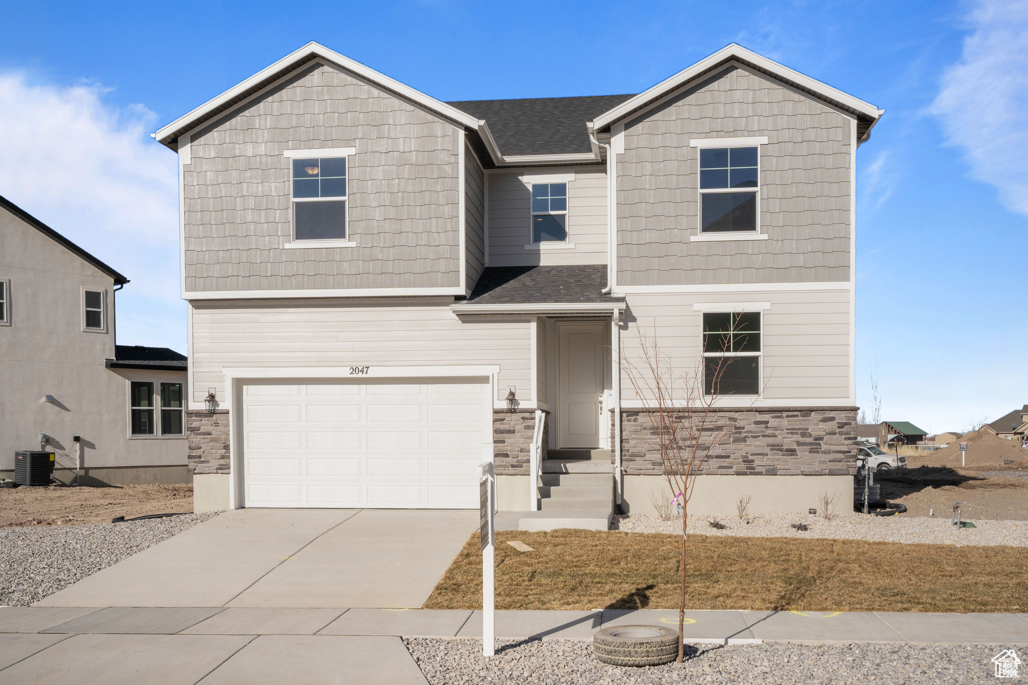 View of front of property with a garage and central AC unit