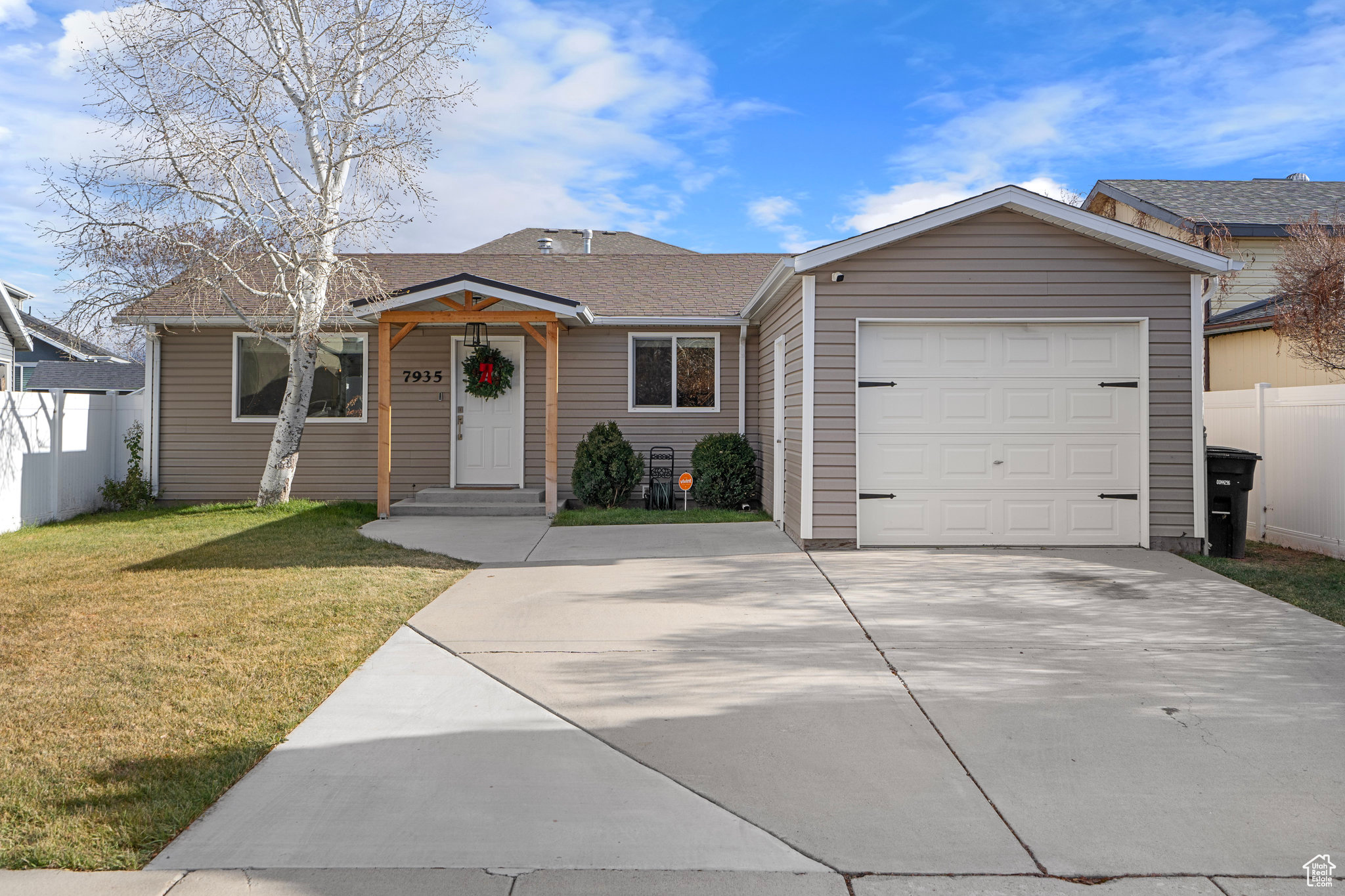 Ranch-style house featuring a garage and a front yard