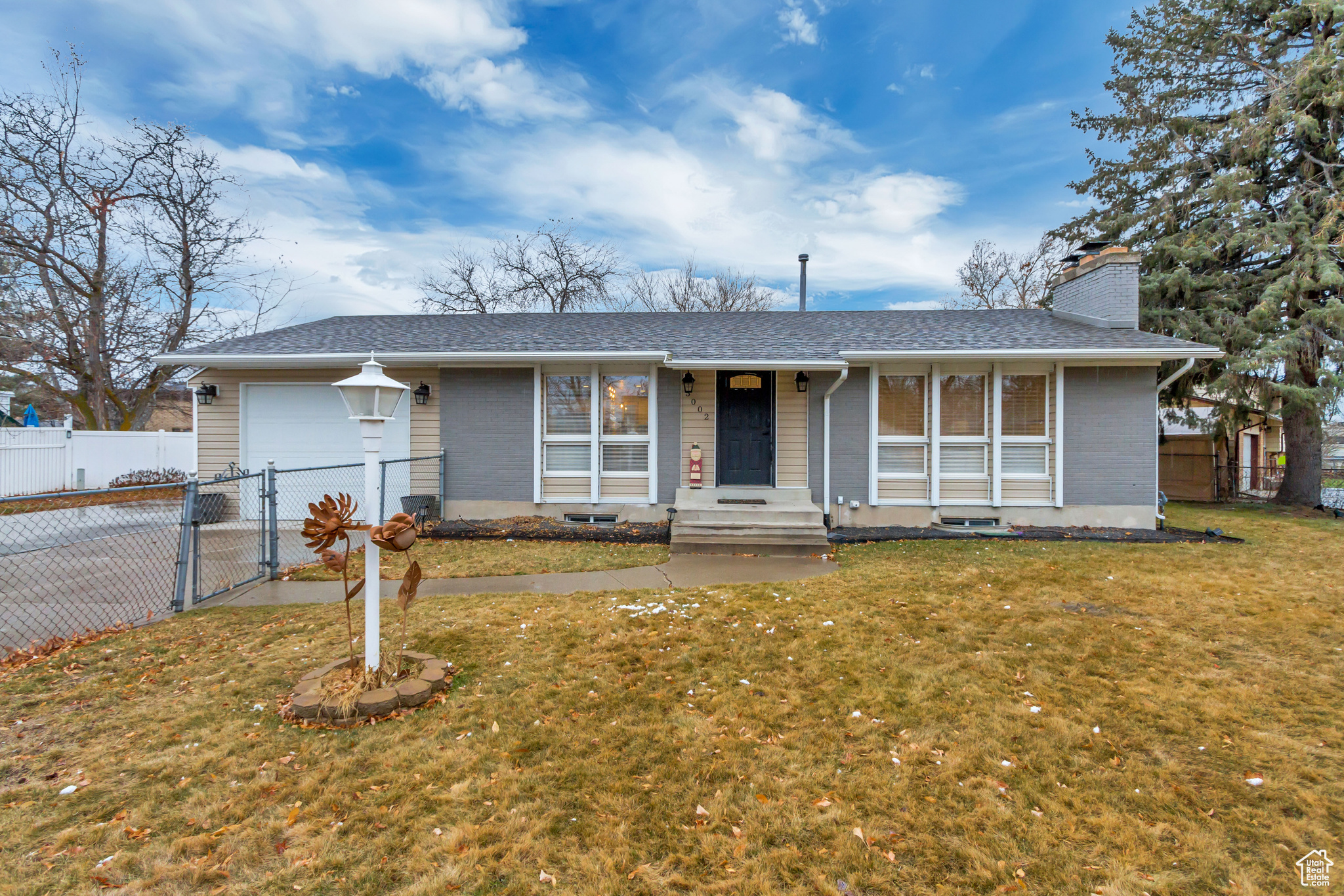 Ranch-style home with a front lawn and a garage