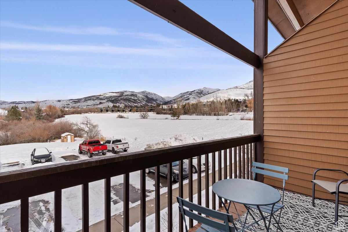 Snow covered back of property with a mountain view