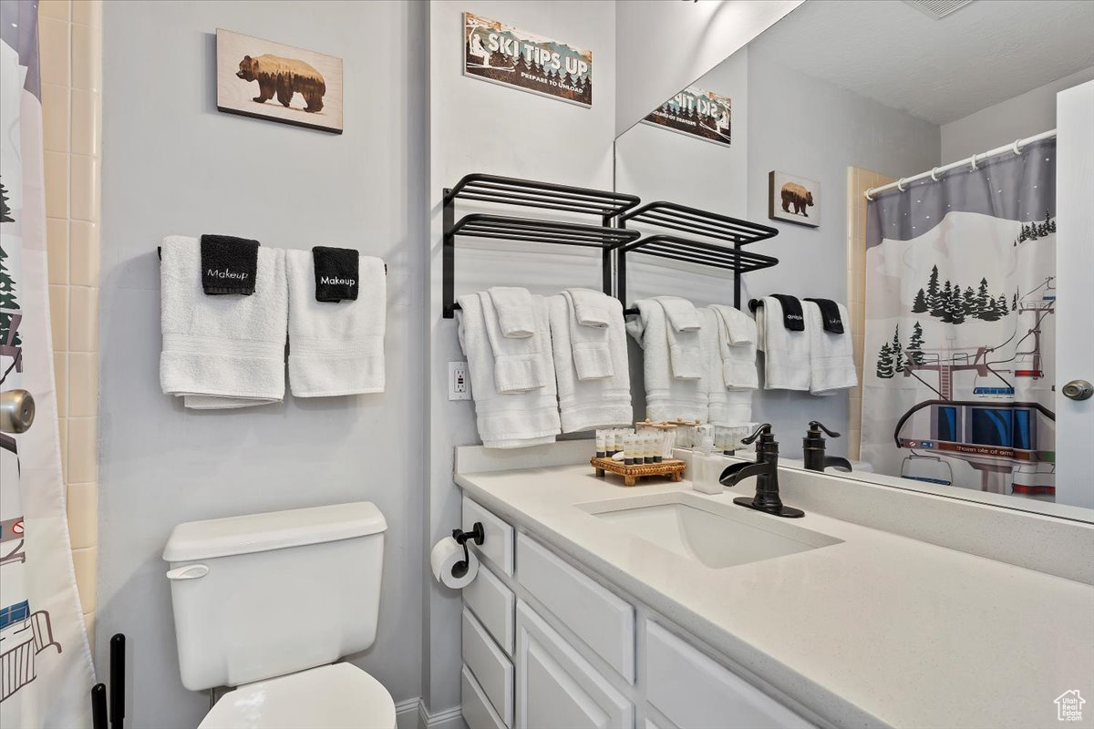 Bathroom with walk in shower, vanity, and toilet