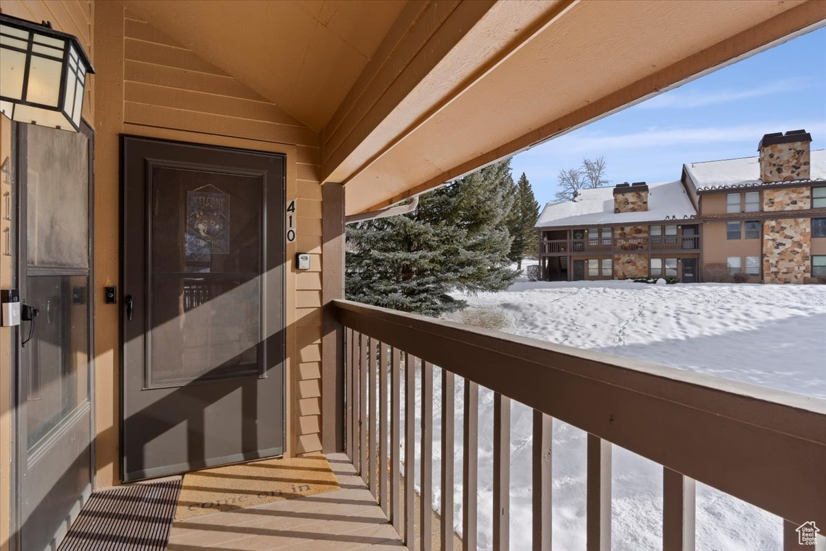 View of snow covered back of property