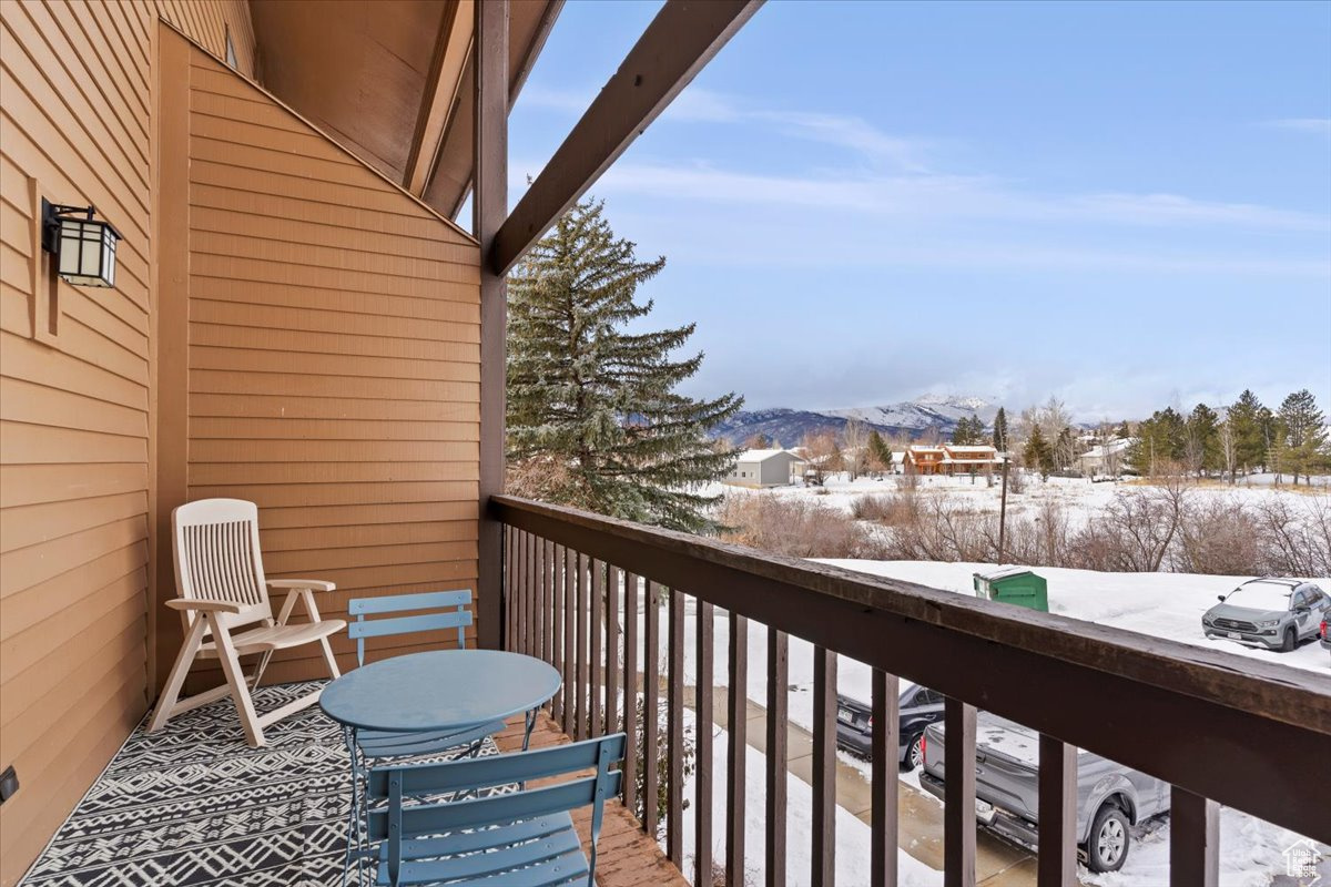 Snow covered back of property with a mountain view