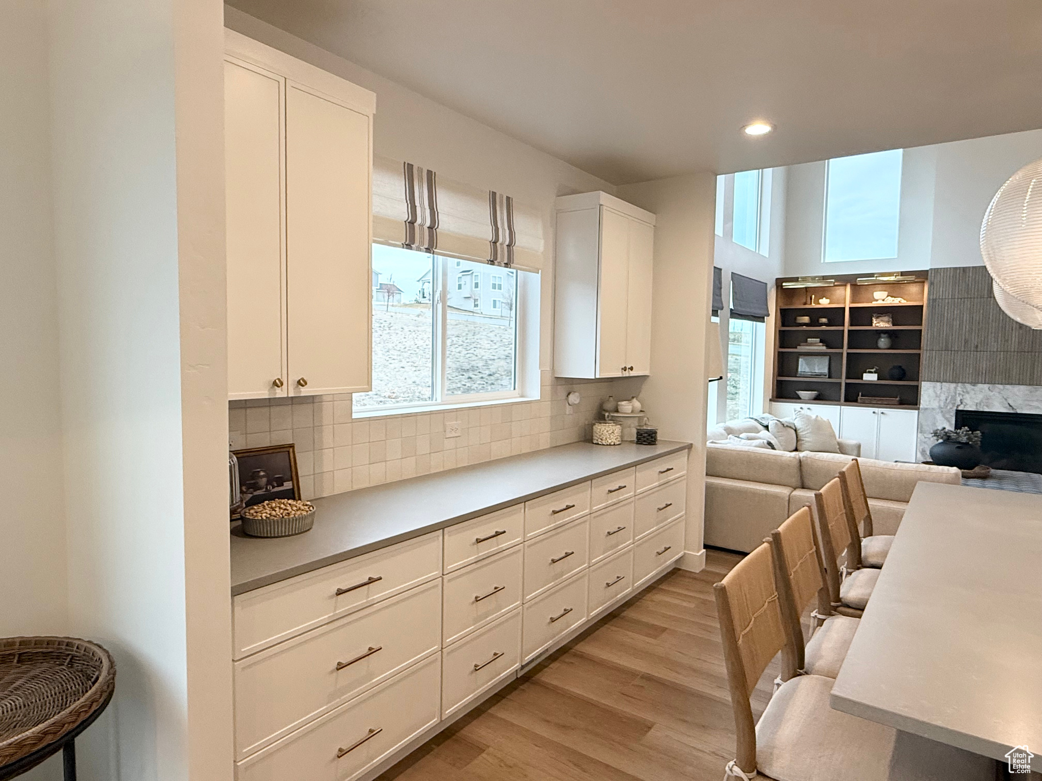 Kitchen featuring white cabinetry, plenty of natural light, a high end fireplace, and light wood-type flooring