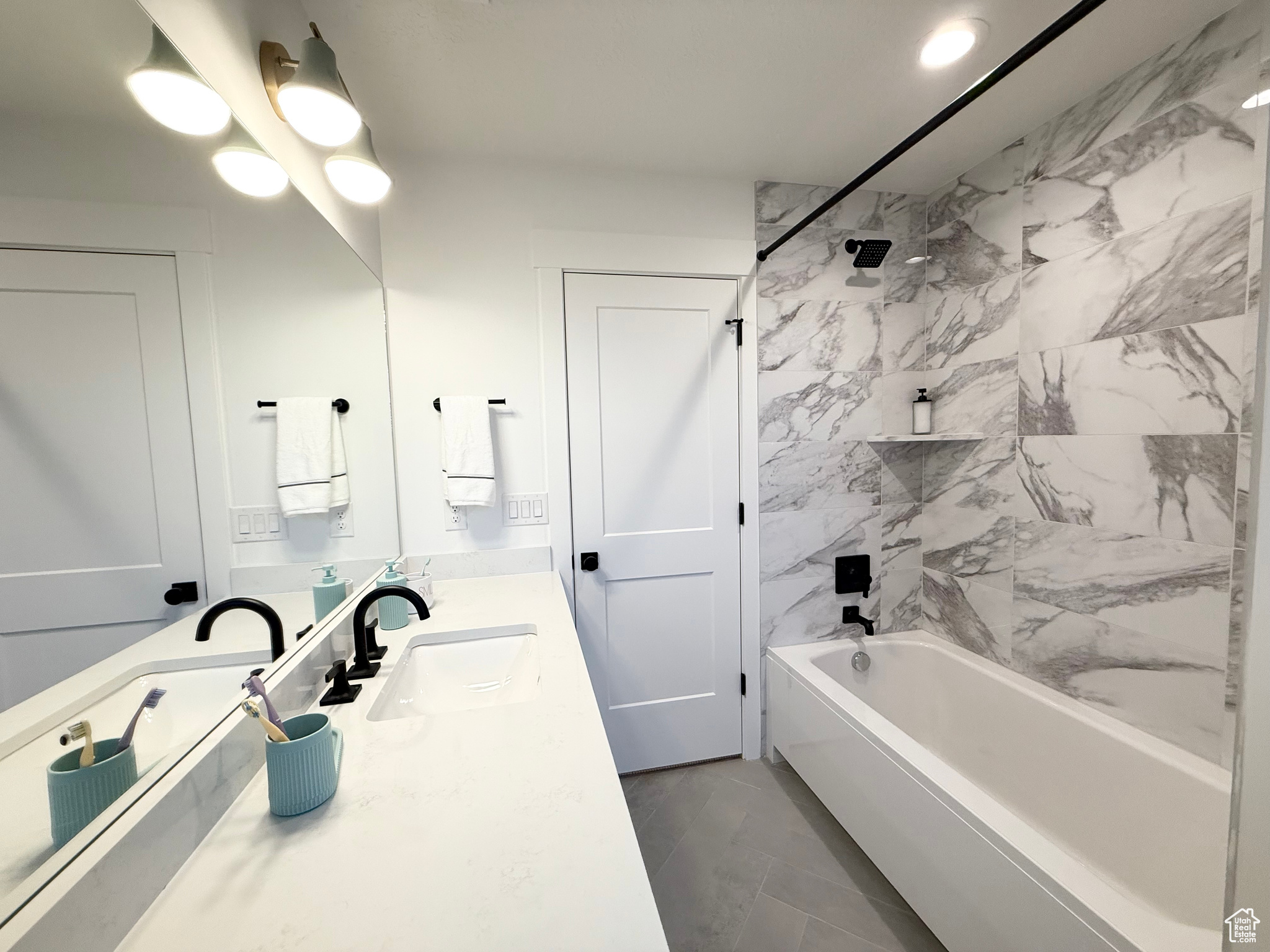 Bathroom with tile patterned flooring, vanity, and tiled shower / bath