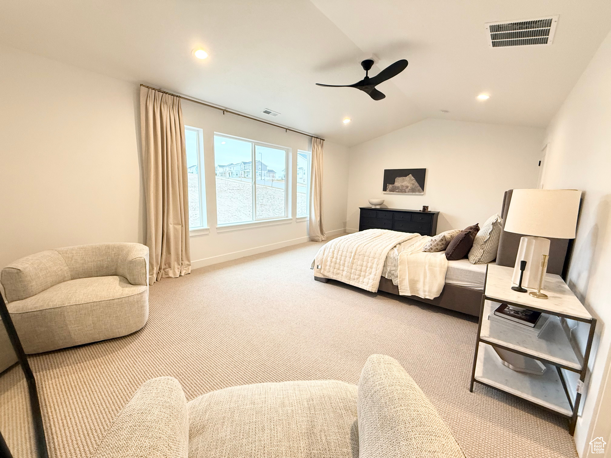 Carpeted bedroom with ceiling fan and lofted ceiling