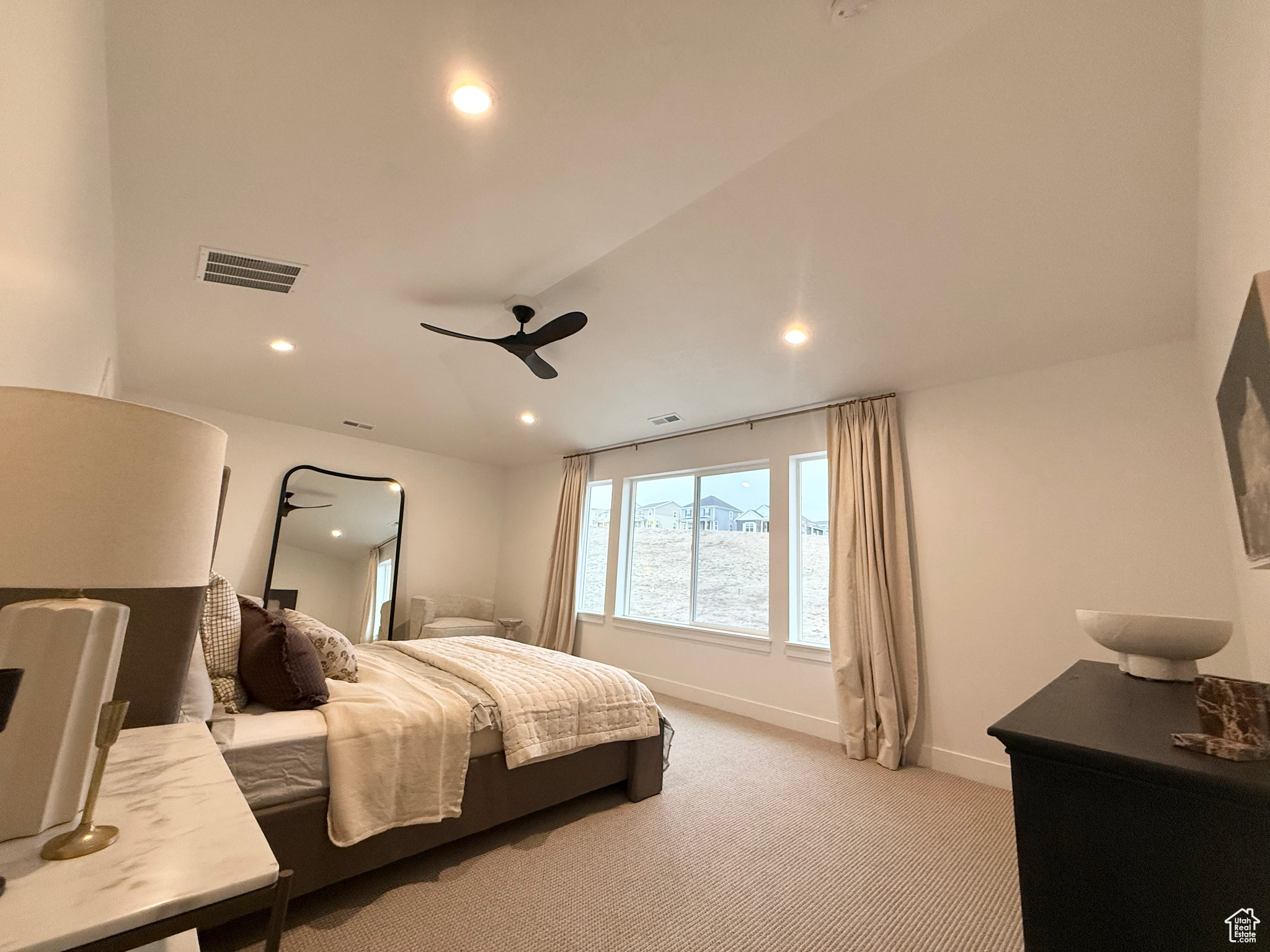 Carpeted bedroom featuring ceiling fan